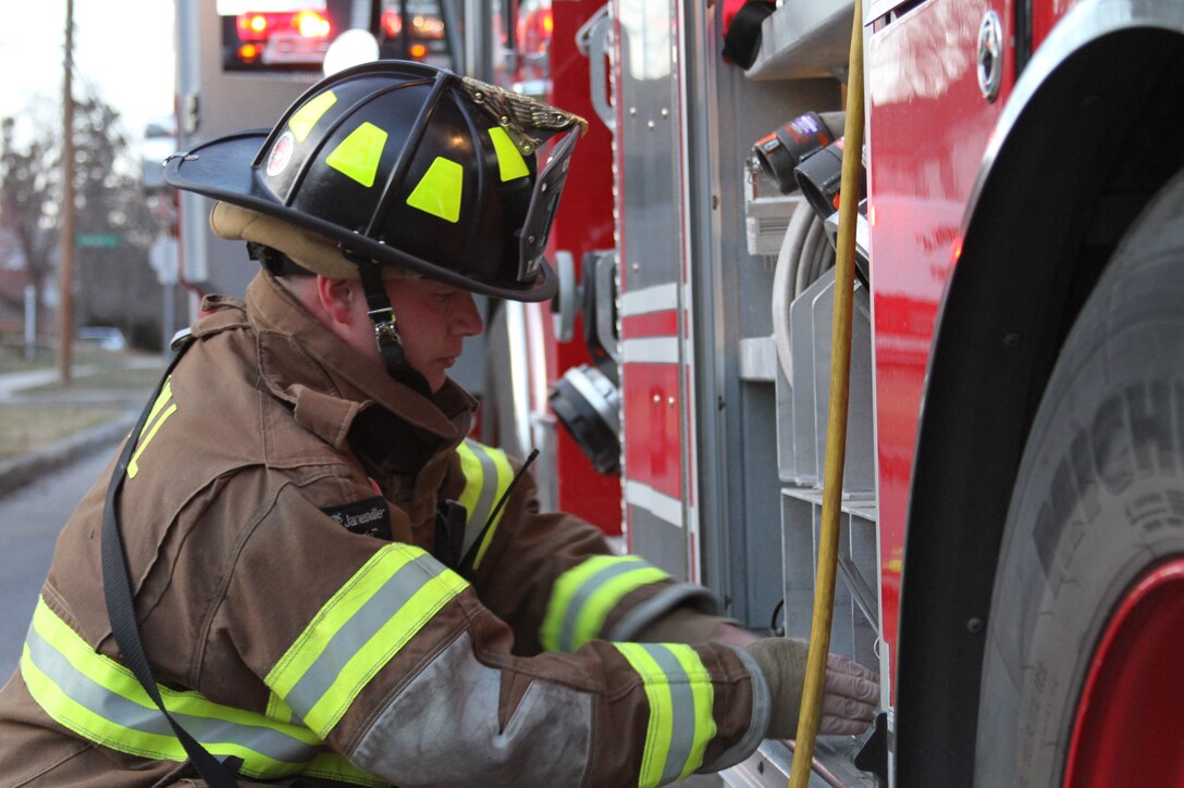 Gunnery Sgt. Travis Albrecht a logistics chief for 4th Marine Corps District and native of LaMarque, Texas, pulls a fire extinguisher out of the fire truck to extinguish part of a chimney fire in Camp Hill, Pa., March 24, 2014. Along with being a Marine, Albrecht has been a volunteer at the Camp Hill Fire Department for four months.  (U.S. Marine Corps photo by Lance Cpl Kyle R. Welshans/Released) 