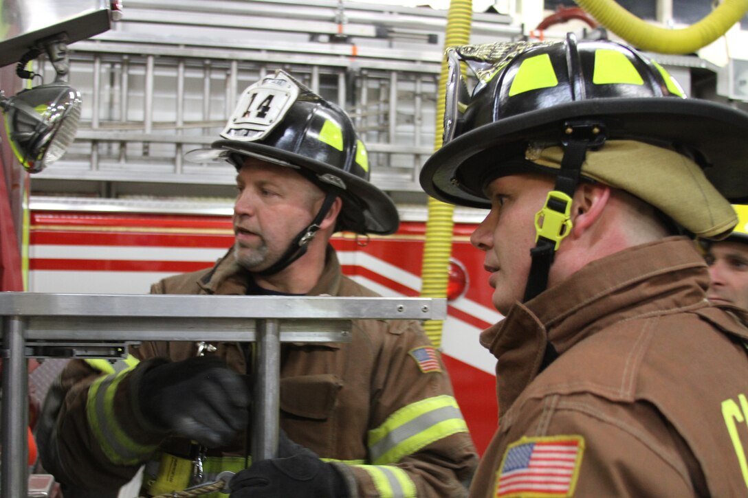 Tony Derr, left, the fire captain for the Camp Hill Fire Department and training chief shows Gunnery Sgt. Albrecht, the logistics chief for 4th Marine Corps District, how to properly pull out a 16-foot ladder at the fire station in Camp Hill, Pa., March 24, 2014. Along with being a Marine, Albrecht, a native of LaMarque, Texas, has been a volunteer at the Camp Hill Fire Department for four months. (U.S. Marine Corps photo by Lance Cpl Kyle R. Welshans/Released)
