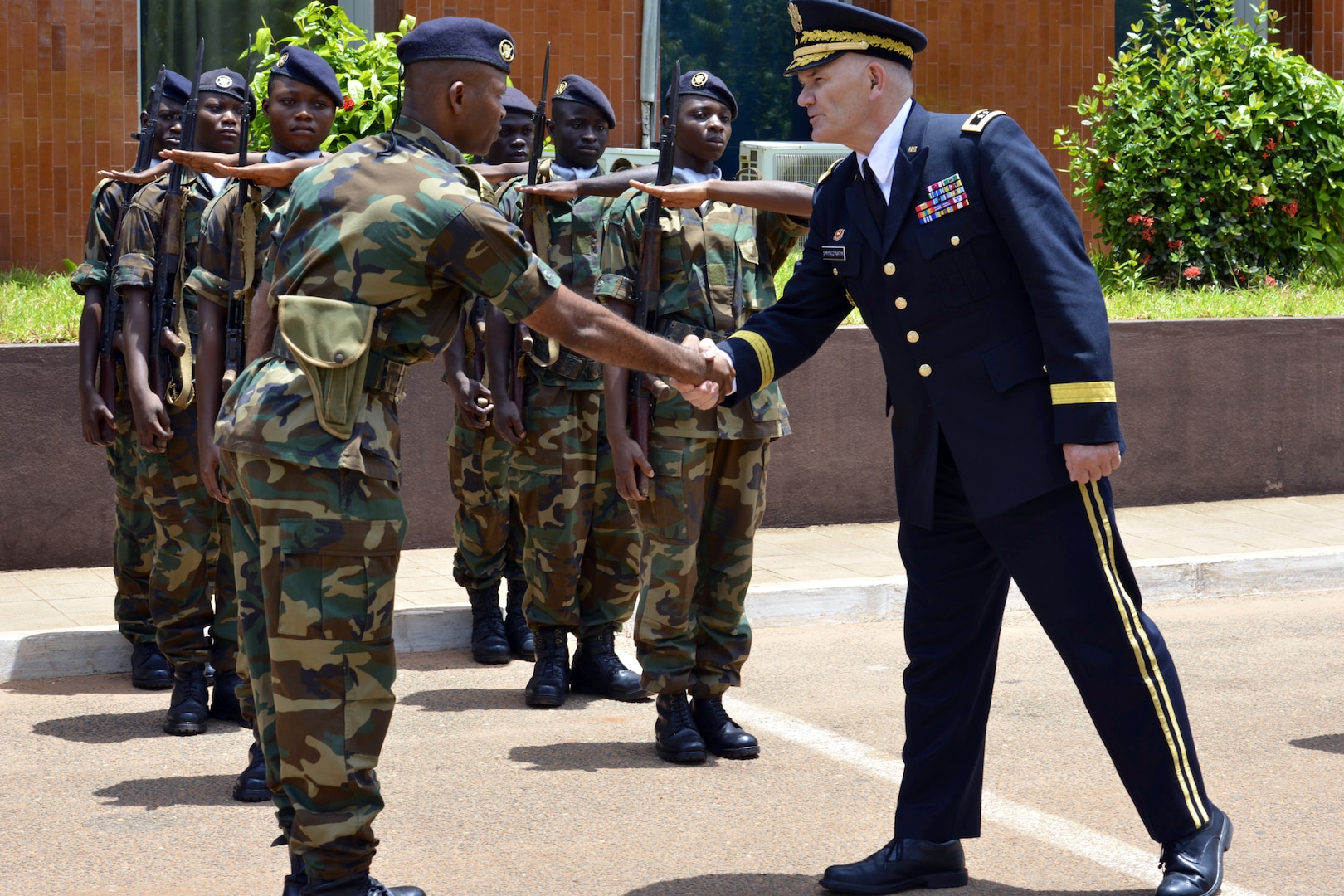 Maj. Gen. David Sprynczynatyk, North Dakota adjutant general, greets a troop leader of the Togolese Armed Forces in front of the military headquarters at Lome, Togo, on April 4, 2014. The greeting occurred during a ceremony in which the North Dakota National Guard formalized its association with the Togolese Republic under the auspices of the National Guard Bureau’s State Partnership Program.