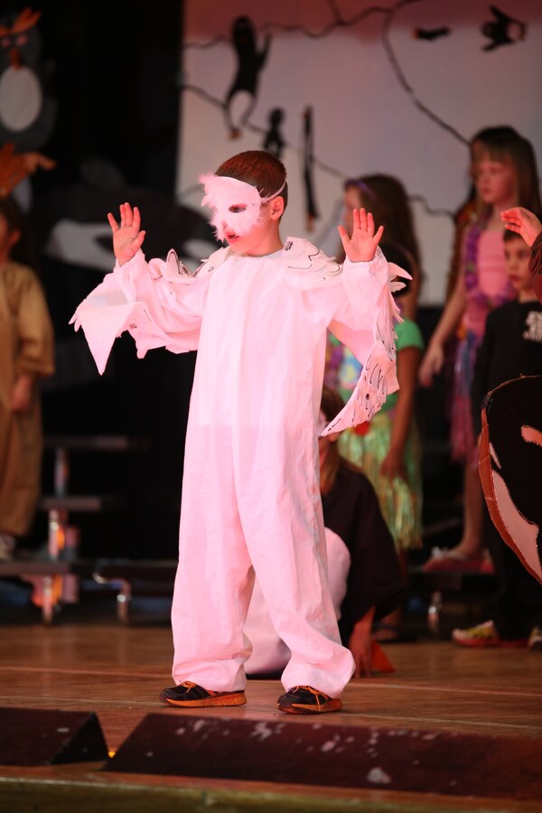 Jayden, a student at John H. Russell Elementary School on Marine Corps Base Quantico, sings about animals that live around the North Pole while dressed as a snowy owl during a musical presentation about the wonders of the earth on April 3, 2014. The students dressed as different animals from their respective regions for the production. 