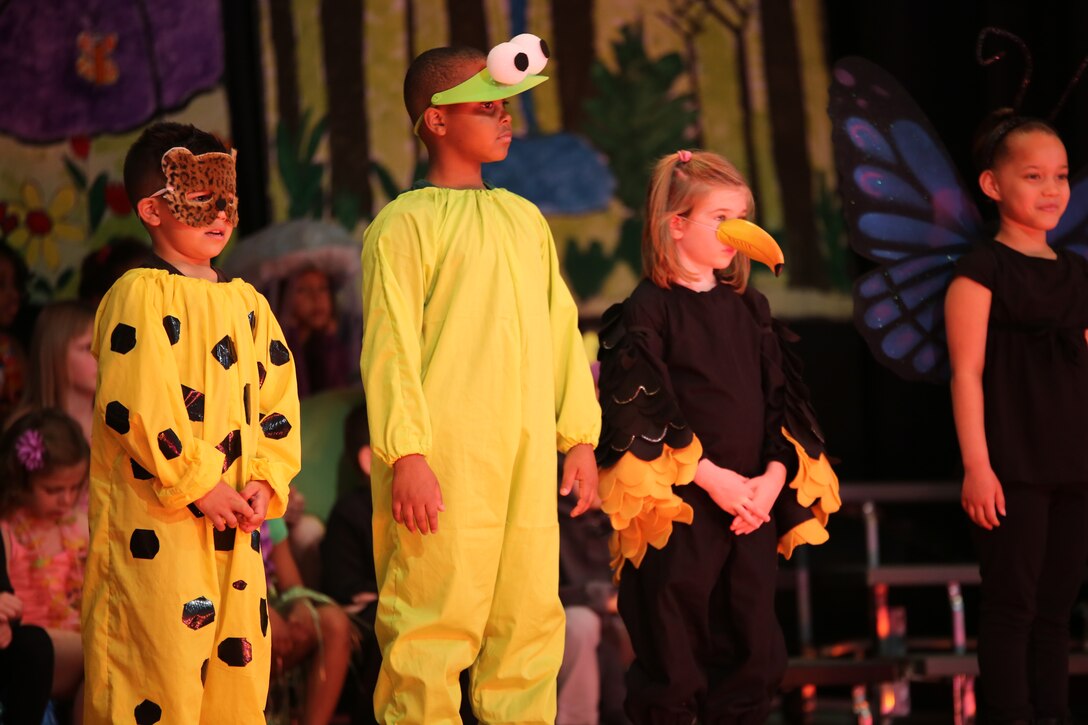Alex, Canon and Kathryn, students at John H. Russell Elementary School on Marine Corps Base Quantico, sing about the plants and animals of the rainforest during a musical production about the wonders of the earth on April 3, 2014. The teachers used music and singing to help the students learn about continents, islands and animals that live on them and in the ocean.