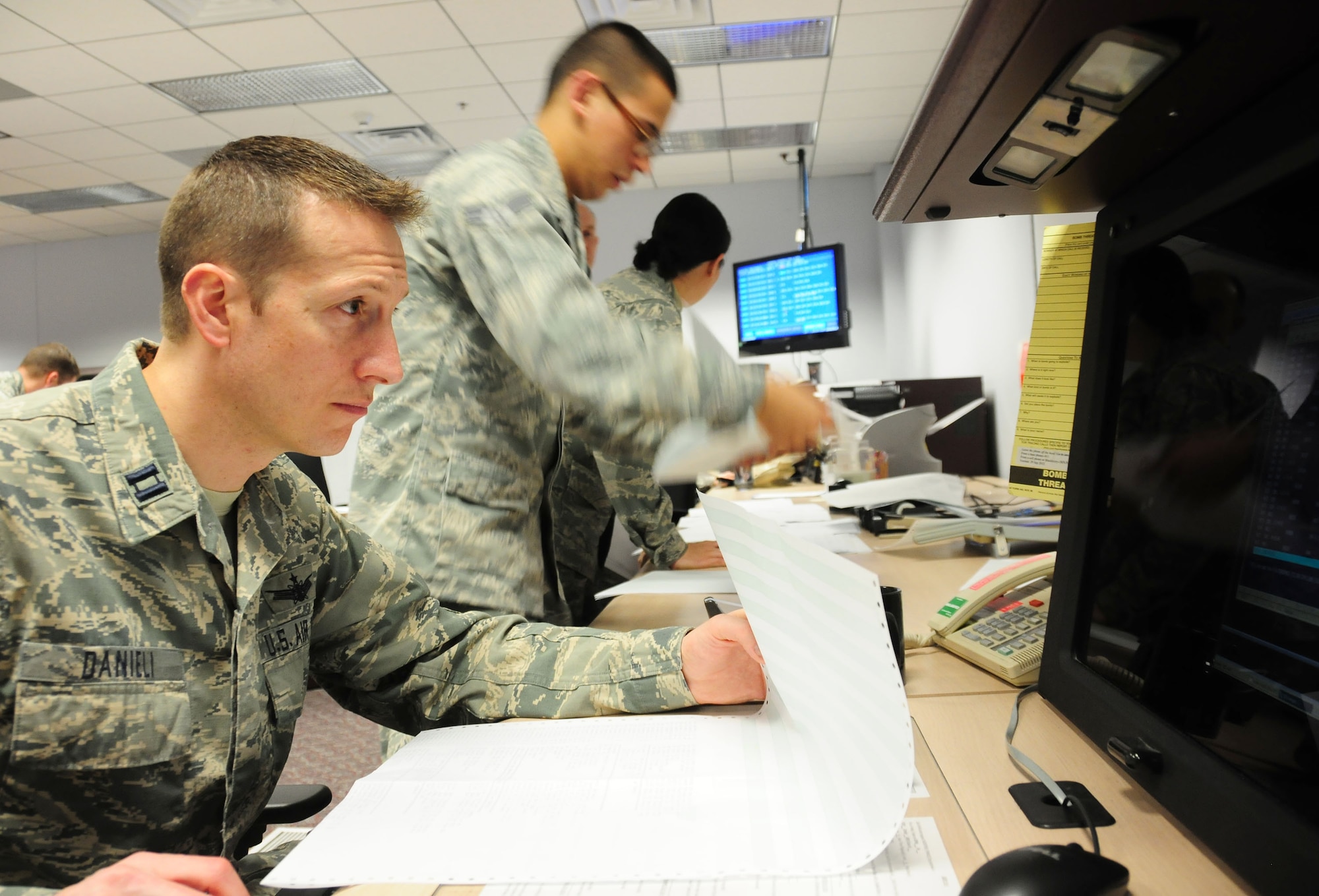 Capt. Jason Danieli, left, reviews upload instructions for a weather satellite as fellow 6th Space Operations Squadron members organize data instruction uploads for other satellites April 3, 2014 at Schriever Air Force Base, Colo. The squadron's satellite vehicle operators assumed command of the nation's Defense Meteorological Satellite Program weather satellites from their National Oceanic and Atmospheric Administration counterparts as the nation's newest weather satellite lifted into orbit aboard an Atlas V rocket at Vandenberg AFB, Calif. The squadron will oversee all weather satellite operations until April 8. Danieli is a satellite vehicle operator with the 6th SOPS. (U.S. Air Force photo/Tech. Sgt. Stephen J. Collier)