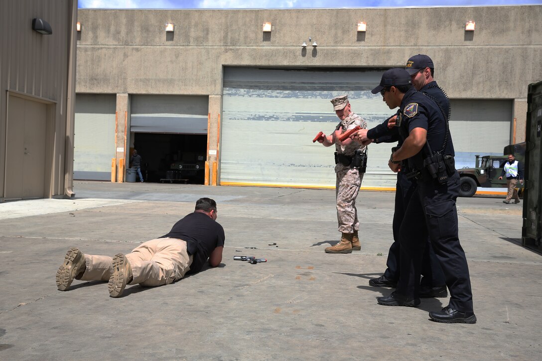 MARINE CORPS AIR STATION MIRAMAR, Calif.—Military and civilian police officers, with the Marine Corps Air Station Miramar Provost’s Marshall Office, force a suspect on the ground during an active shooter exercise at the Navy Marine Reserve Center aboard Marine Corps Air Station Miramar, Calif., April 2. The exercise was conducted to test the officer’s readiness in the event of a real emergency.