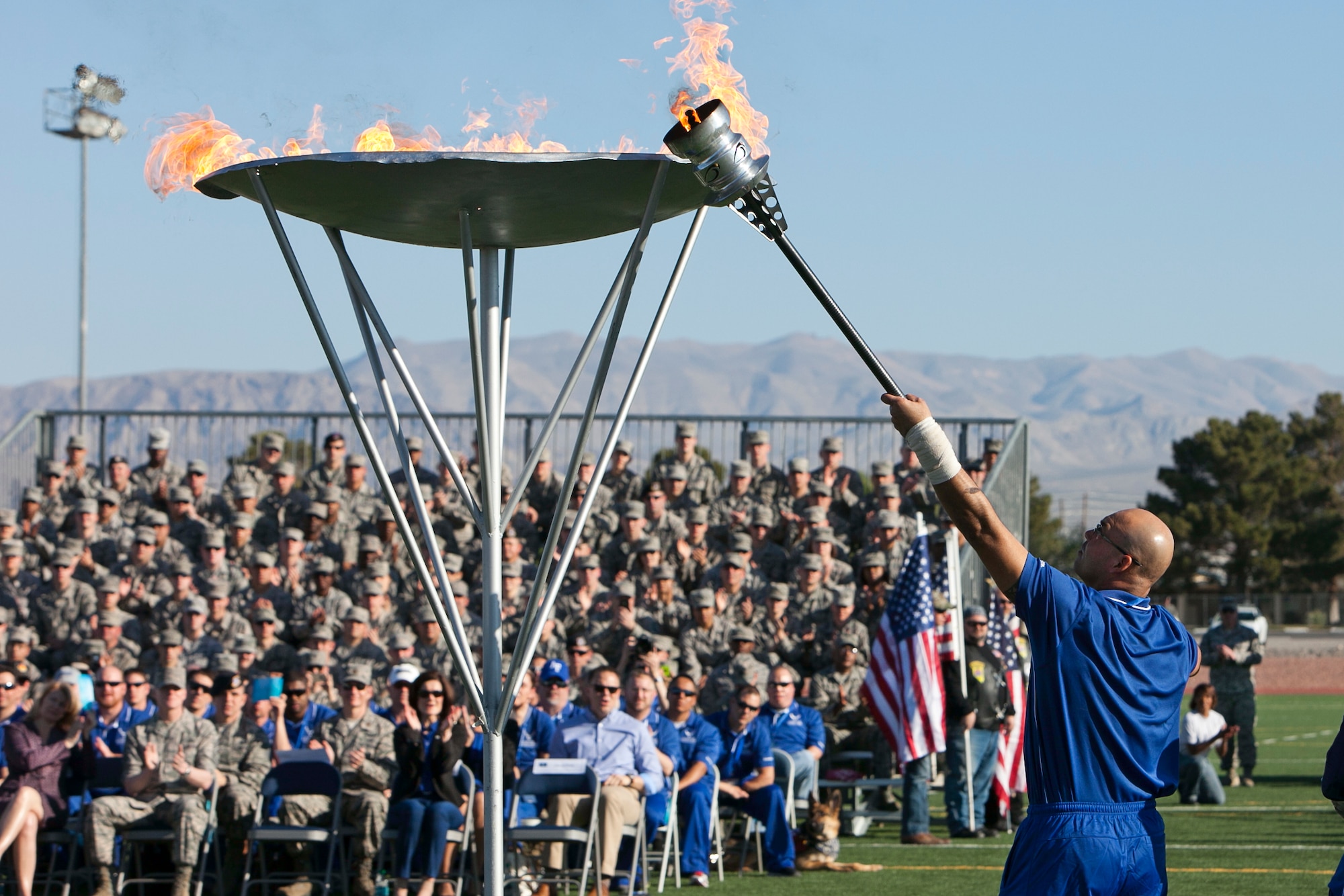 Master Sgt. Christopher Aguilera lights the cauldron signifying the beginning of the Air Force Wounded Warrior Trails April 7, 2014, at Nellis Air Force Base, Nev. Aguilera, who is a survivor of the June 9, 2010 “Pedro 66” helicopter crash in southwest Afghanistan, will participate in in seven events during the trials. (U.S. Air Force photo/Lorenz Crespo)
