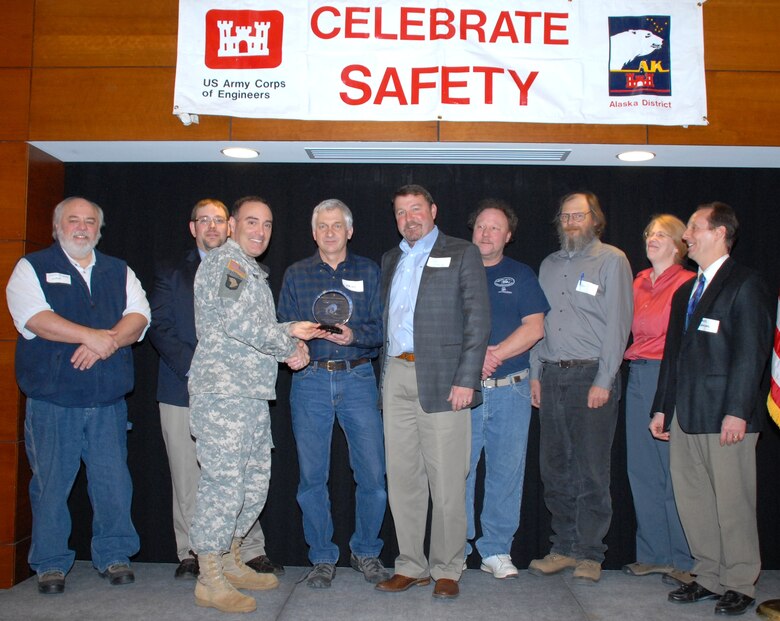 Surrounded by representatives of the Army Corps of Engineers and Western Marine Construction, Col. Christopher Lestochi, district commander, presents Kriss Hart, president of Western Marine Construction, the 2013 Celebrate Safety Contractor of the Year award during a ceremony at Joint Base Elmendorf-Richardson April 2.