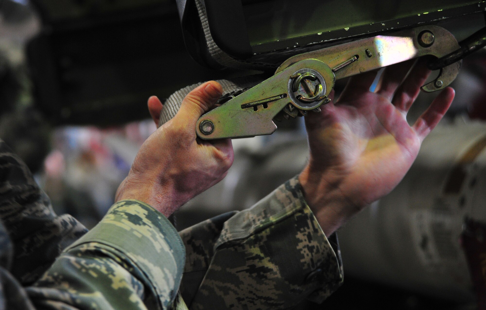 U.S. Air Force Staff Sgt. Joshua Sisneros, 14th Aircraft Maintenance Unit weapons load crew chief, unwinds a steel strapping tensioner, during the Weapons Load Crew Competition of the Quarter at Misawa Air Base, Japan, April 4, 2014. Load crew team members must work hand-in-hand with one another to ensure safety when handling weapons. (U.S. Air Force photo/Senior Airman Jose L. Hernandez-Domitilo)