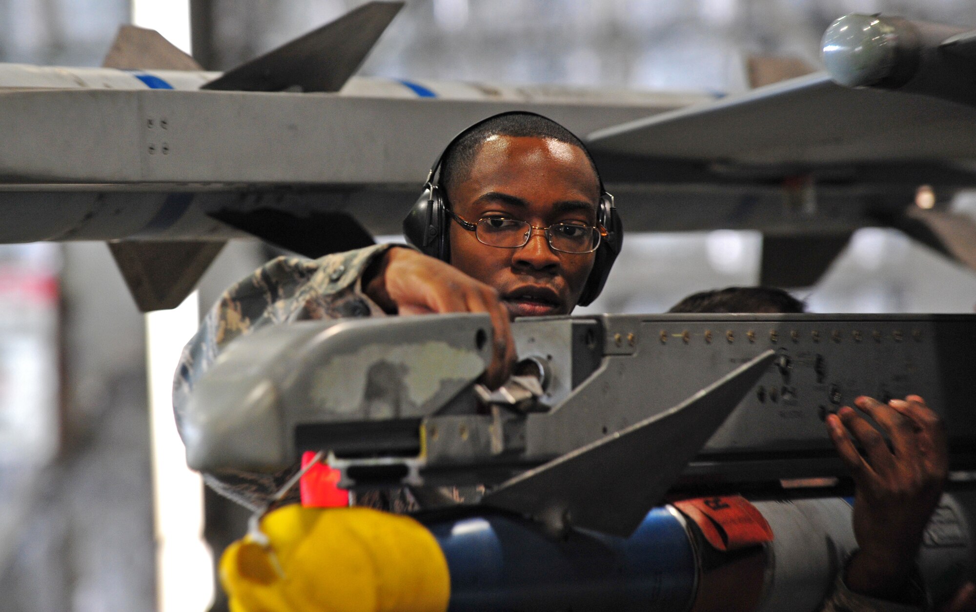 U.S. Air Force Senior Airman Mekai Stewart, 13th Aircraft Maintenance Unit weapons load crew member, ensures a weapons system is correctly placed on an F-16 Fighting Falcon at Misawa Air Base, Japan, April 4, 2014. The weapons load crew members must be precise in their placing of the weapon, as this is crucial for the safety of all equipment. (U.S. Air Force photo/Senior Airman Jose L. Hernandez-Domitilo)