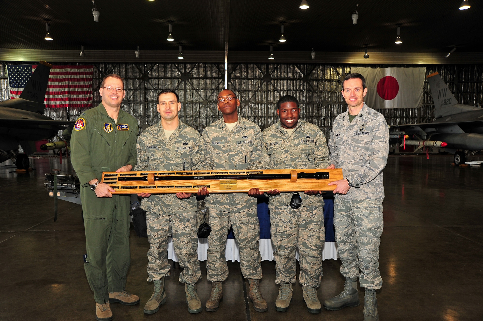 The 14th Aircraft Maintenance Unit weapons load crew team is presented with the trophy for the Weapons Load Crew of the Quarter Competition by Col. Stephen Williams, 35th Fighter Wing commander and Col. Benjamin Davis, 35th Maintenance Group commander, at Misawa Air Base, Japan, April 4, 2014. The 14 AMU received the highest points after being evaluated on dress and appearance, best load, CTK inspection, and a written test. (U.S. Air Force photo/Senior Airman Jose L. Hernandez-Domitilo)