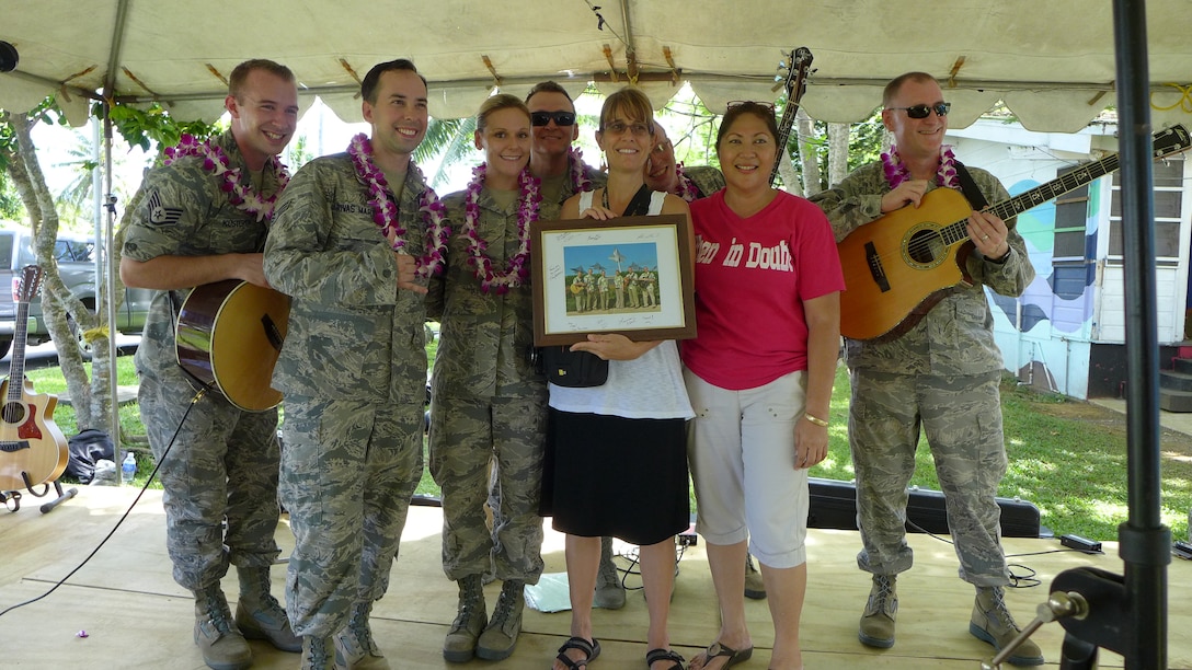 PAGO PAGO, American Samoa-- Small Kine presented Caroline Tuiolosega, principal of the Pacific Horizons School, with a signed photograph of the group on March 27, 2014. (US Air Force Photo/ TSgt Michael Smith/ Released)
