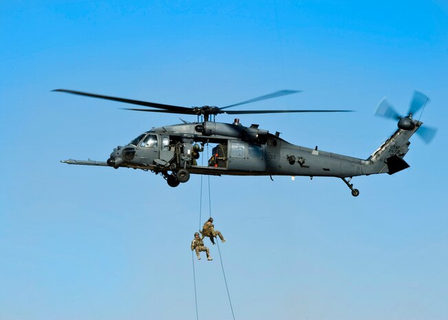 Capt. Michael Ellingsen, 58th Rescue Squadron combat rescue officer, and Master Sgt. Corey Kuttie, 58th RQS pararescueman rappel out of an HH-60G Pave Hawk helicopter assigned to the 66th Rescue Squadron April 7, 2014, at Nellis Air Force Base, Nev. The demonstration was part of the opening ceremony for the Air Force Wounded Warrior Trials. The trials will identify the most skilled wounded warrior athletes and end with two specific teams selected. (U.S. Air Force Photo by Senior Airman Jason Couillard)