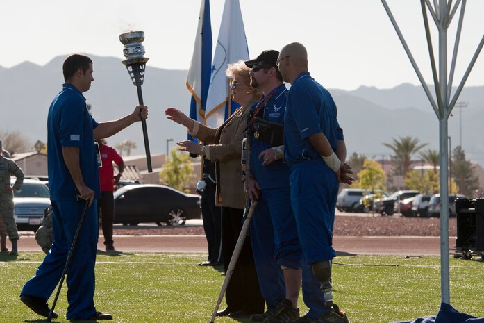 August O’Neill, Air Force Wounded Warrior participant passes the torch to Mrs. Carolyn Goodman, Las Vegas Mayor as Tony Simone and Master Sgt. Christopher Aguilera, AF Wounded Warrior athletes look on April 7, 2014, at Nellis Air Force Base, Nev.   The Air Force Wounded Warrior team will include athletes with upper-body, lower-body and spinal cord injuries; serious illness; traumatic brain injuries; visual impairment and post-traumatic stress disorder.  (U.S. Air Force Photo by Senior Airman Christopher Tam)