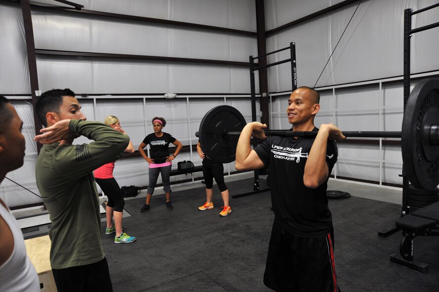 Life of a Warrior Instructors Staff Sgts. German Lechuga and Richard Quino Jr. discuss proper form during a Creech Functional Fitness kick-off event March 28, 2014. The fitness program is designed with general scalability in mind to allow anyone to achieve their fitness goals regardless of athletic experience level. (U.S. Air Force photo by Tech. Sgt. S.E./Released)