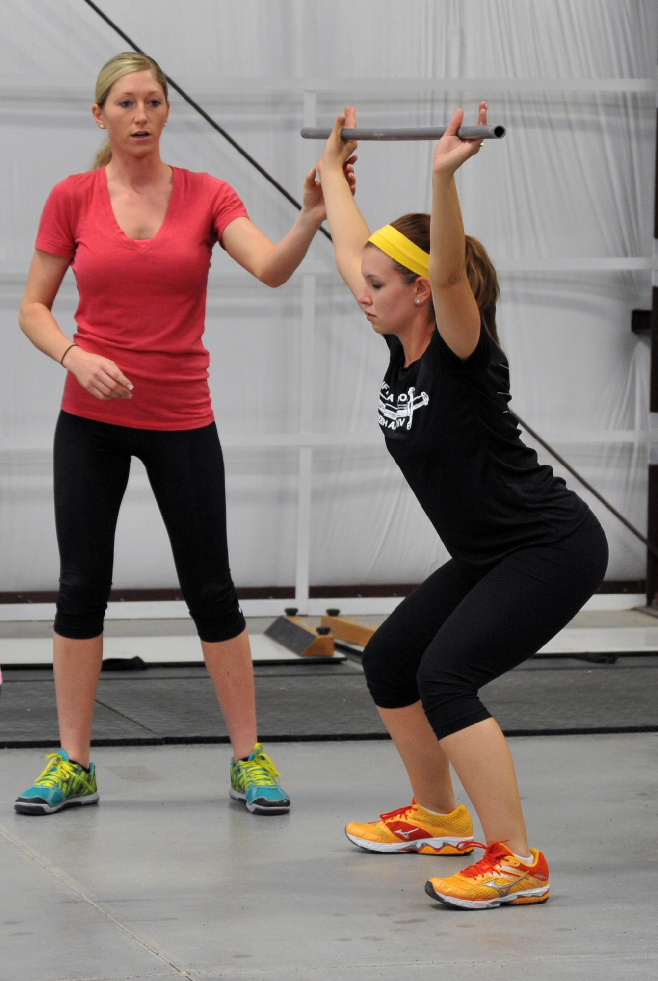 Staff Sgt. Ashley Gregory, Life of a Warrior instructor (left), helps Airman 1st Class Hannah Howey, 799th Security Forces Squadron knowledge operations manager, hold a strengthening pose during a Creech Functional Fitness kick-off event March 28, 2014. The strength and conditioning class improves core fitness by combining cardiovascular endurance, stamina, strength, speed, agility and coordination to build a well-rounded, physically fit athlete. (U.S. Air Force photo by Tech. Sgt. S.E./Released)
