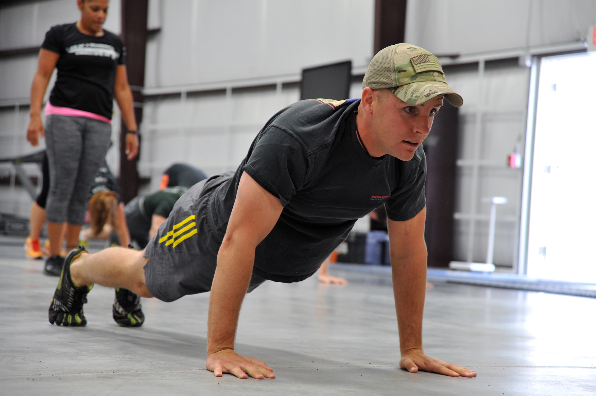 Capt. Sean May, 99th Ground Combat Training Squadron officer in charge of operations, does pushups during a Creech Functional Fitness kick-off event March 28, 2014. The fitness class was created to provide a great workout environment and to allow people to meet likeminded individuals looking for new ways to improve their fitness level. (U.S. Air Force photo by Tech. Sgt. S.E./Released)