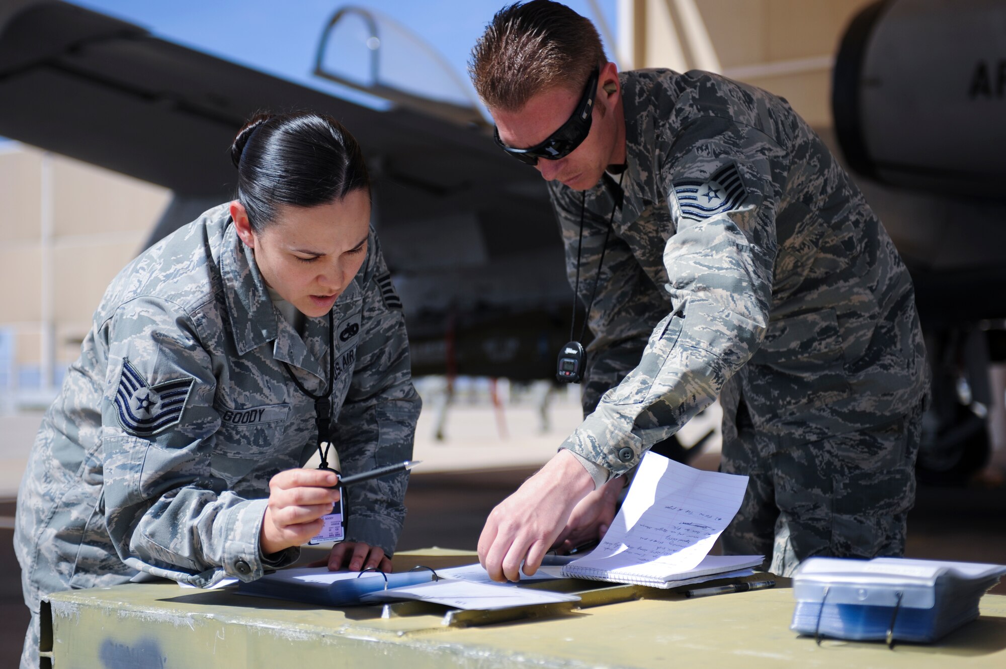 U.S. Air Force Tech. Sgts. Loraine Goody and Ronald Legarde, 355th Maintenance Group load crew competition judges, review a checklist during a load crew competition at Davis-Monthan Air Force Base, Ariz., April 4, 2014. The judges ensure that participants follow all the rules and safety guidelines of arming an aircraft. (U.S. Air Force photo by Senior Airman Sivan Veazie/Released)