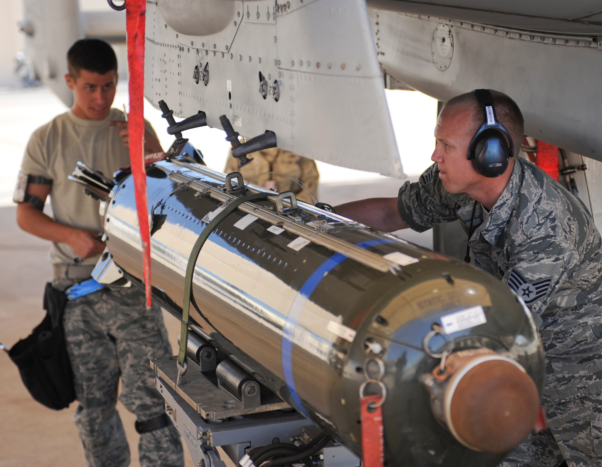 U.S. Air Force Staff Sgt. Bryan Kessler, 924th Aircraft Maintenance Unit team chief, guides ammunition for installment on an A-10 Thunderbolt II during a load crew competition at Davis-Monthan Air Force Base, Ariz., April 4, 2014. Load crew competitions are held quarterly for Airmen to display their skills while also being recognized for their superior performance. (U.S. Air Force photo by Senior Airman Sivan Veazie/Released)