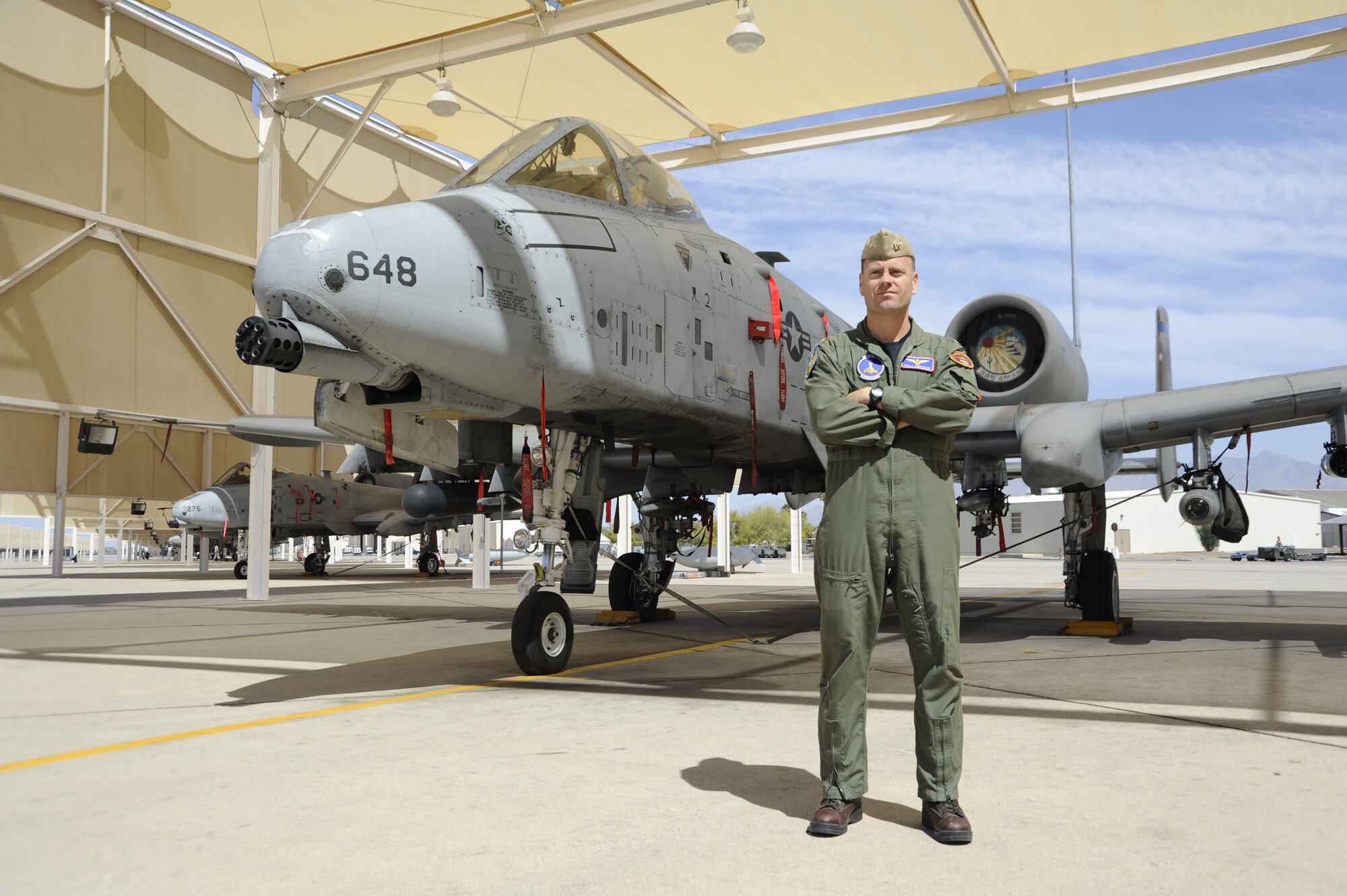 U.S. Navy Lieutenant Commander Eric Anderson, 354th Fighter Squadron assistant director of operations, poses for a hero shot in front of an A-10C Thunderbolt II at Davis-Monthan Air Force Base, Ariz., April 2, 2014. Anderson is part of a program that allows the Air Force and the Navy to exchange pilots, in order to expand their knowledge of other military branches. (U.S. Air Force photo by Airman 1st Class Betty R. Chevalier/released)
