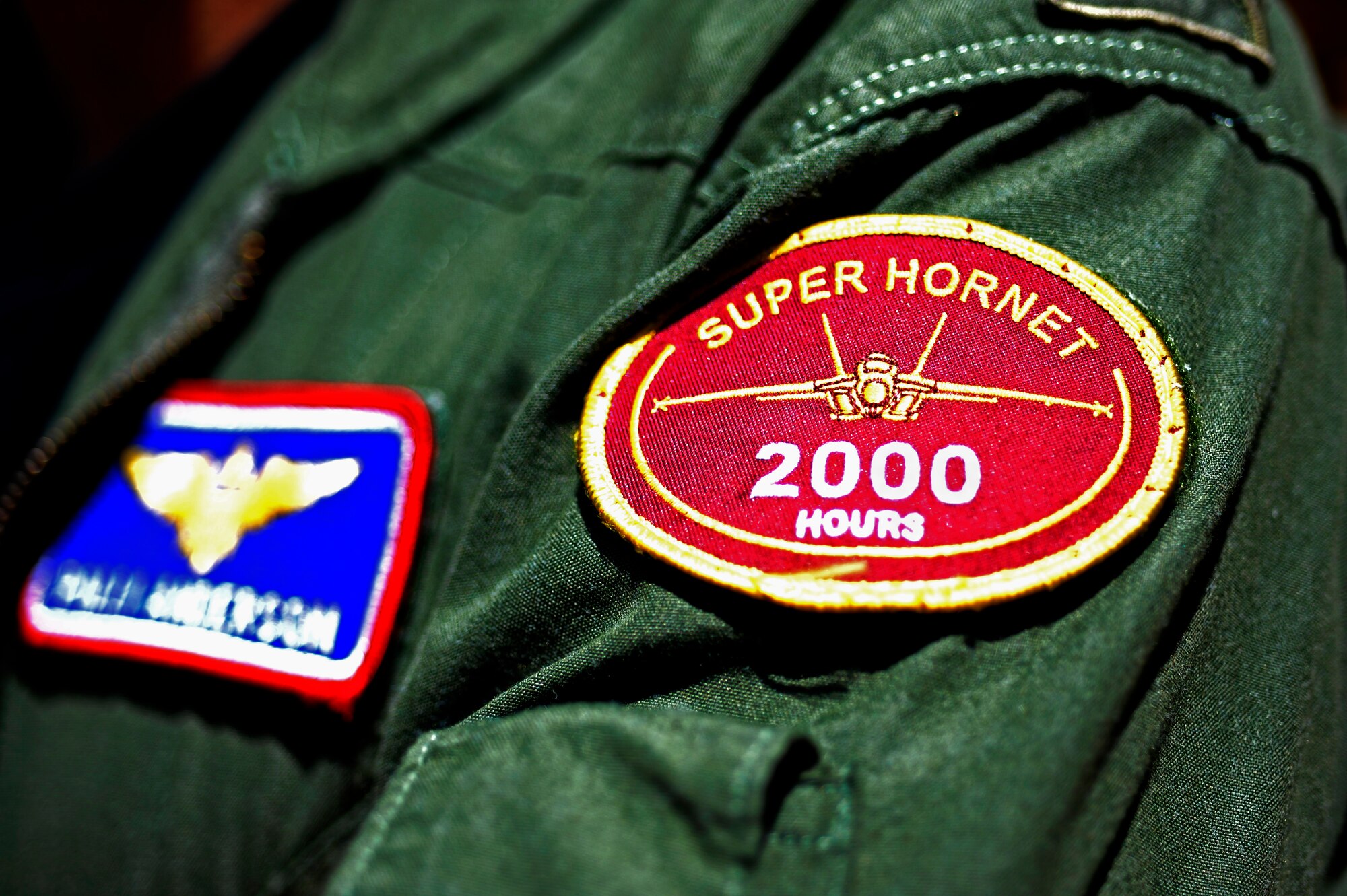A patch sticks to the sleeve of U.S. Navy Lieutenant Commander Eric Anderson, 354th Fighter Squadron assistant director of operations, at Davis-Monthan Air Force Base, Ariz., April 2, 2014. This patch shows his accomplishment of flying over 2000 hours on the F/A-18F Super Hornet. (U.S. Air Force photo by Airman 1st Class Betty R. Chevalier/released)