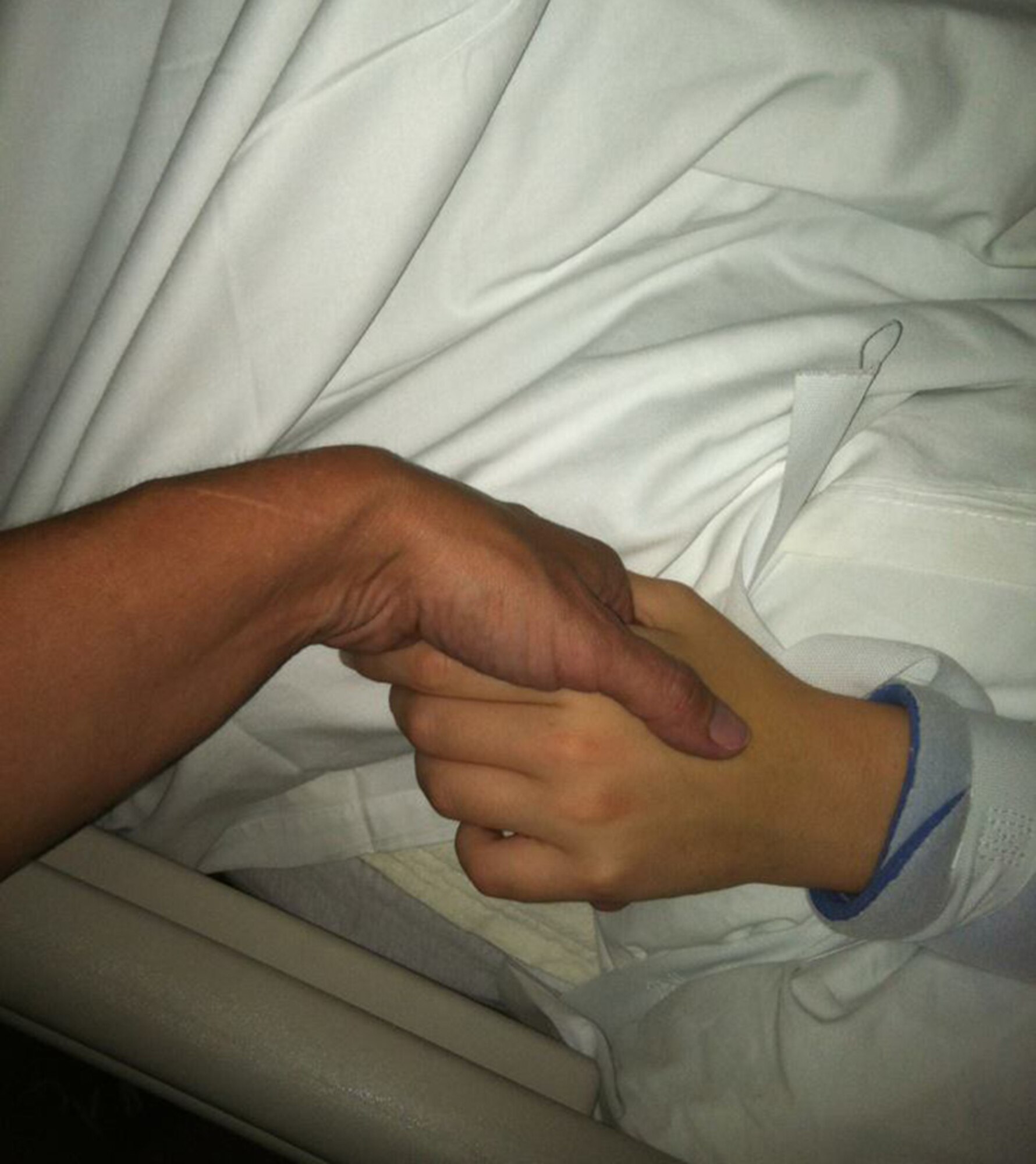 Skapik holds the hand of her eldest child, daughter Katy, who was involved in a car accident in 2012, suffered a traumatic brain injury and was lifted by Careflight to Miami Valley Hospital where she was treated for three months. (Photo by Tara Dixon Engel)