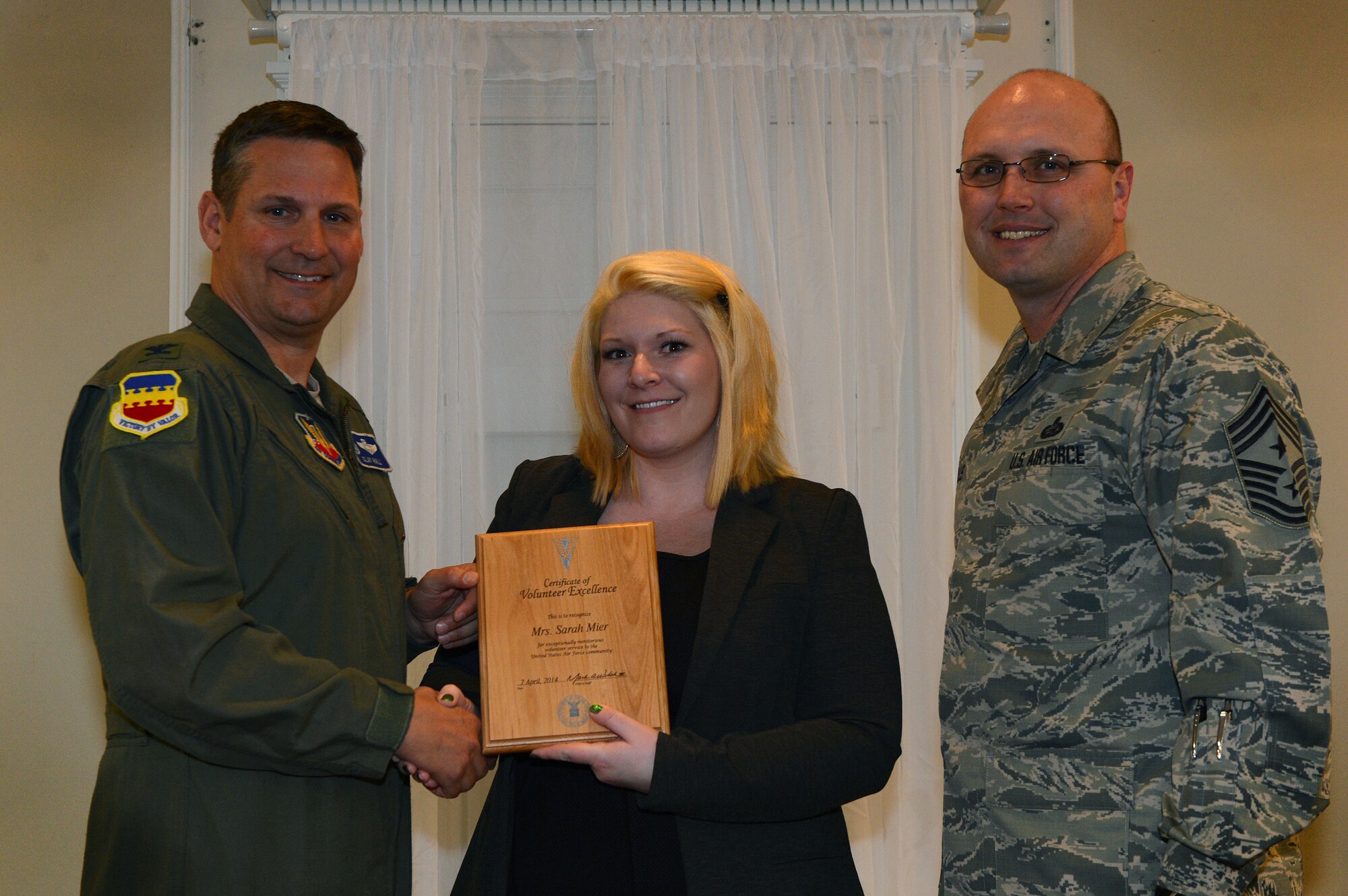 U.S. Air Force Col. Clay Hall, 20th Fighter Wing commander, presents Sarah Mier with a certificate of volunteer excellence at Shaw Air Force Base, S.C., April 7, 2014. Hall along with Chief Master Sgt. Charles Mills, 20th Fighter Wing command chief, thanked Mier, the 20th Security Forces Squadron key spouse, for all of her hard work throughout the year. (U.S. Air Force photo by Airman 1st Class Jensen Stidham/Released)