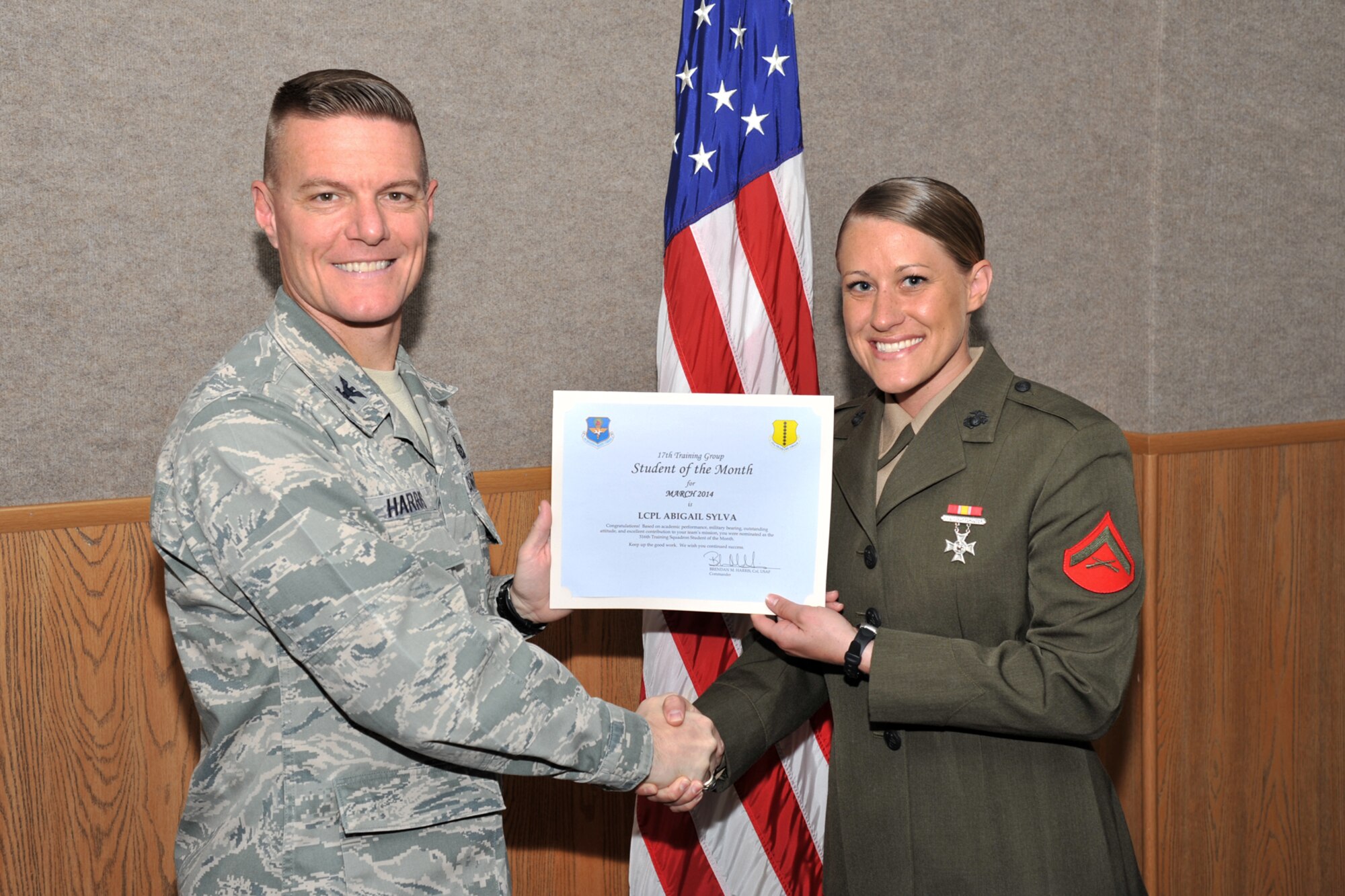 GOODFELLOW AIR FORCE BASE, Texas -- Col. Brendan M. Harris, 17th Training Group Commander, presents the 316th Training Squadron Student of the Month award for March to Marine Corps Lance Cpl. Abigail Sylva April 4. (U.S. Air Force Photo/ Airman 1st Class Devin Boyer)
