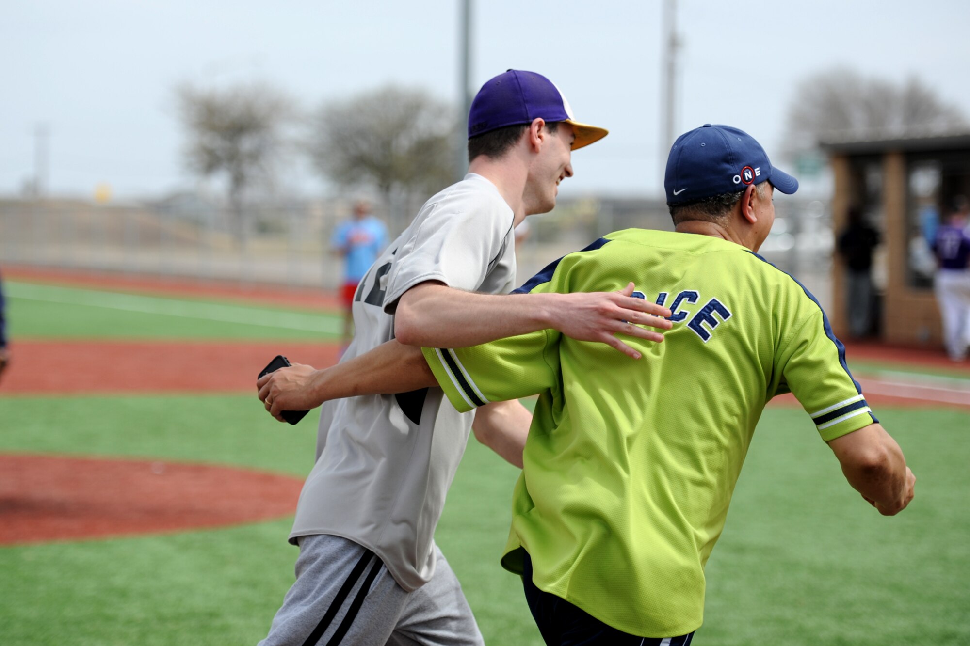 GOODFELLOW AIR FORCE BASE, Texas-- Chief Master Sgt. William E. Price, 17th Communications Squadron superintendent, runs with Senior Airman Taylor D. Vaughan, 17th CS Communications Focal Point technician and softball team member, after hitting a home run during the Mathis Fitness Center multipurpose field grand opening tournament here March 21. The tournament allowed members of 17th Mission Support Group to try out the newly turfed multipurpose field. (U.S. Air Force photo/Senior Airman Michael Smith)