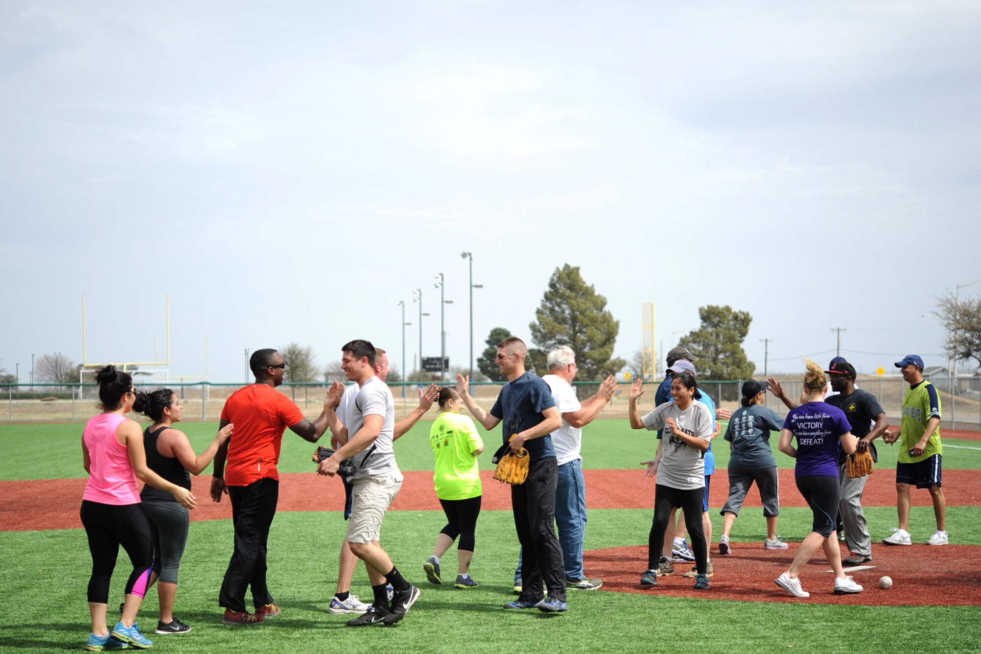 GOODFELLOW AIR FORCE BASE, Texas-- The 17th Force Support Squadron and 17th Communications Squadron softball teams shake hands after a game during the Mathis Fitness Center multipurpose field grand opening tournament here March 21. The tournament consisted of six teams playing 30-minute single elimination games. (U.S. Air Force photo/Senior Airman Michael Smith)