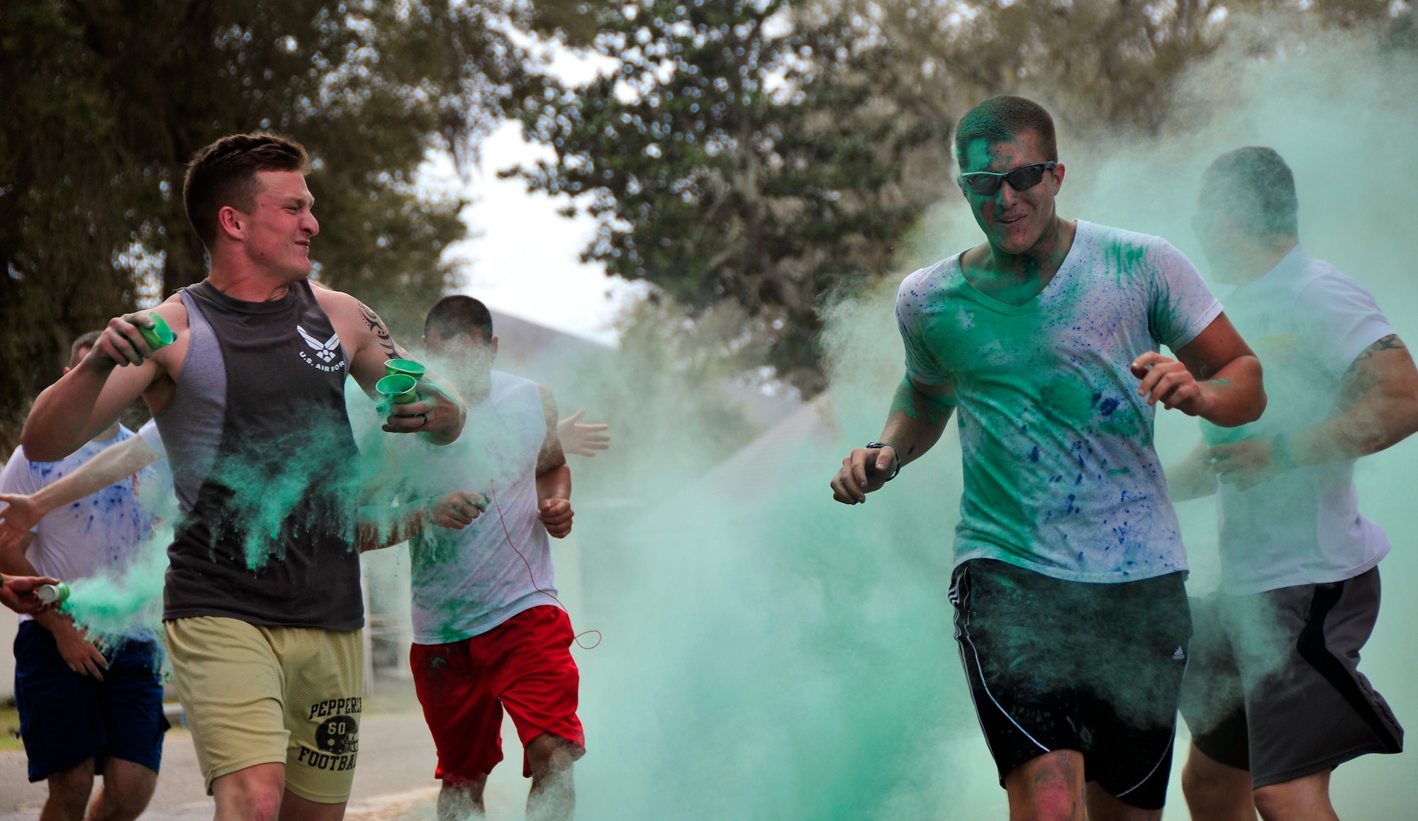 A volunteer gets ready to throw more green dust as runners pass through a color haze at the Color Me Aware fun run, April 4, at Eglin Air Force Base, Fla.  Approximately 30 volunteers helped more than 450 participants get colorful during three color zones of the three-mile run.  The event highlighted the start of Sexual Assault Awareness Month. (U.S. Air Force photo/Tech. Sgt. Cheryl Foster)