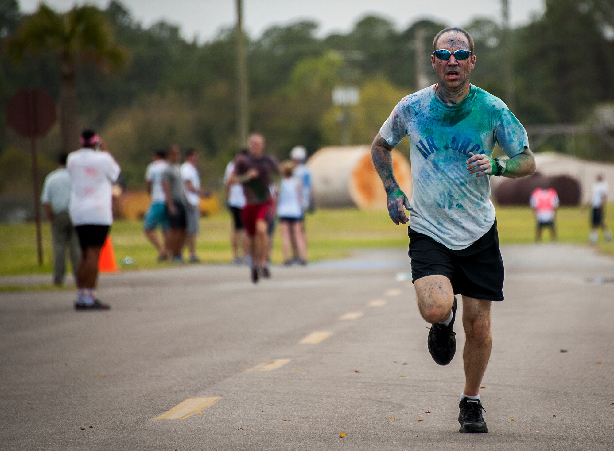A runner strides to the finish line to complete the Color Me Aware fun run, April 4, at Eglin Air Force Base, Fla.  Approximately 30 volunteers helped more than 450 participants get colorful during three color zones of the three-mile run.  The event highlighted the start of Sexual Assault Awareness Month. (U.S. Air Force photo/Sara Vidoni)