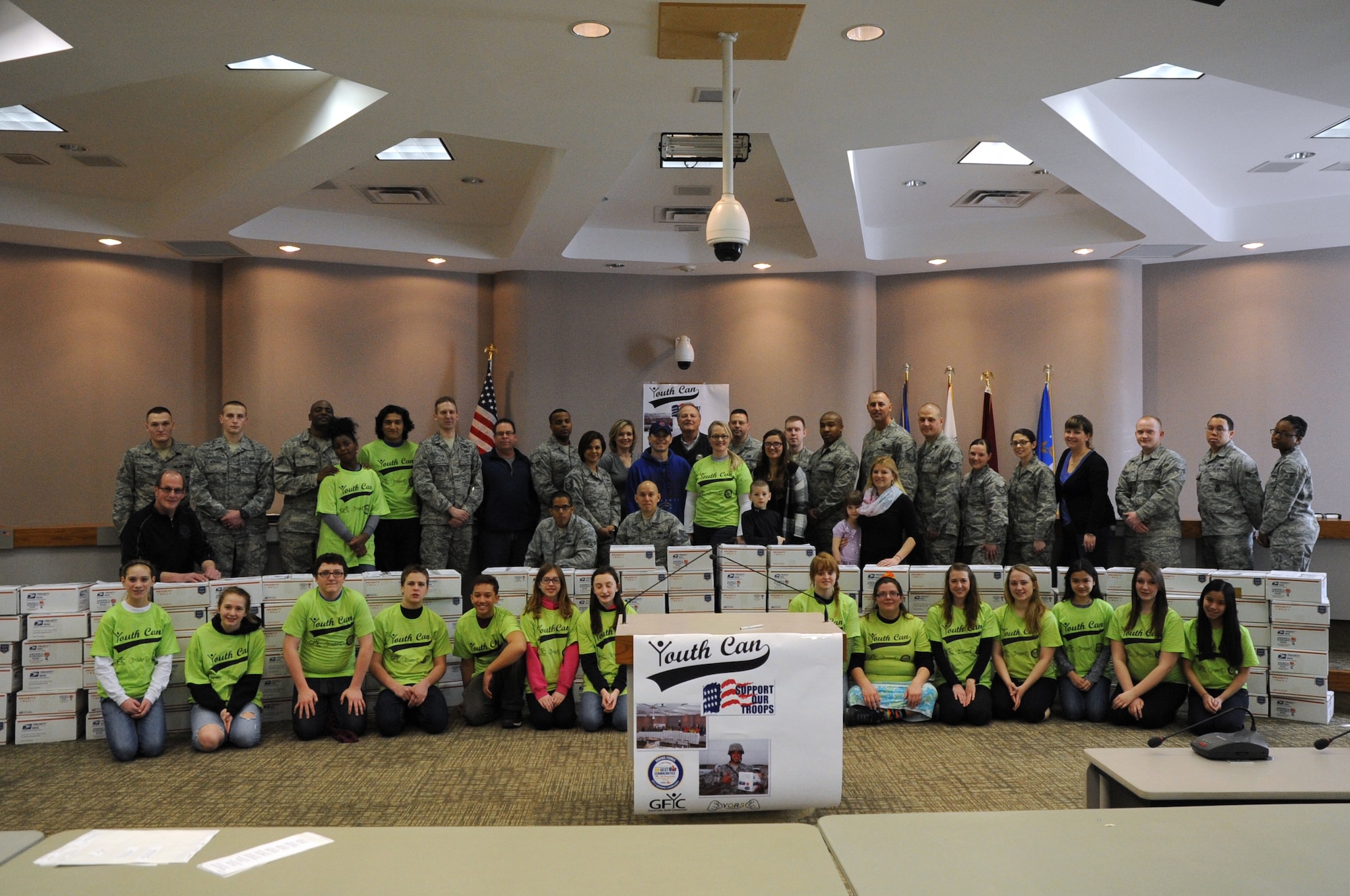 Volunteers from Grand Forks Air Force base and the Grand Forks Youth Commission show the care packages they assembled for the 2nd Annual "Youth Can... Support our Troops" event at the City Hall in Grand Forks, N.D., April 5, 2014. More than 40 volunteers from the base, two high schools and four middle schools packed 192 packages for deployed service members in 45 minutes. (U.S. Air Force photo/Staff Sgt. David Dobrydney)