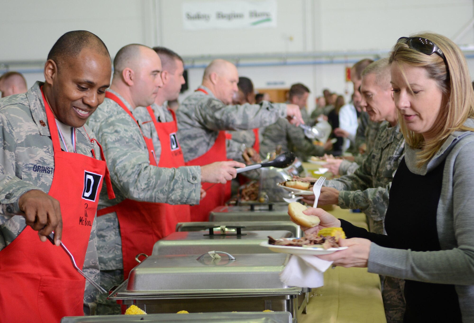 Team Mildenhall leaders serve food to attendees at the 2014 100th Maintenance Group and 100th Logistics Readiness Squadron Knucklebuster Awards April 3, 2014, on RAF Mildenhall, England. The awards recognized Airmen who performed exceptionally not only in their duty sections, but across their squadron as well. (U.S. Air Force photo by Airman 1st Class Dillon Johnston/Released)