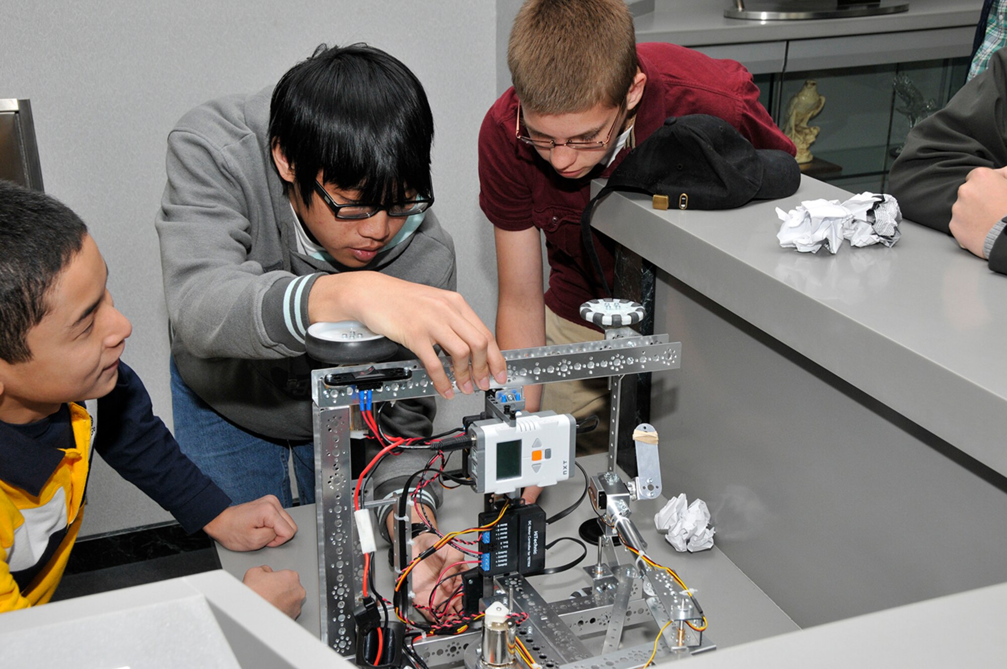 Tullahoma High School students (l-r) Alec Yen, Kevin Nguyen and Dakota Baker examine their FIRST Tech Challenge robot before a demonstration for Arnold Engineering Development Complex Commander Col. Raymond Toth. (Photos by Rick Goodfriend)