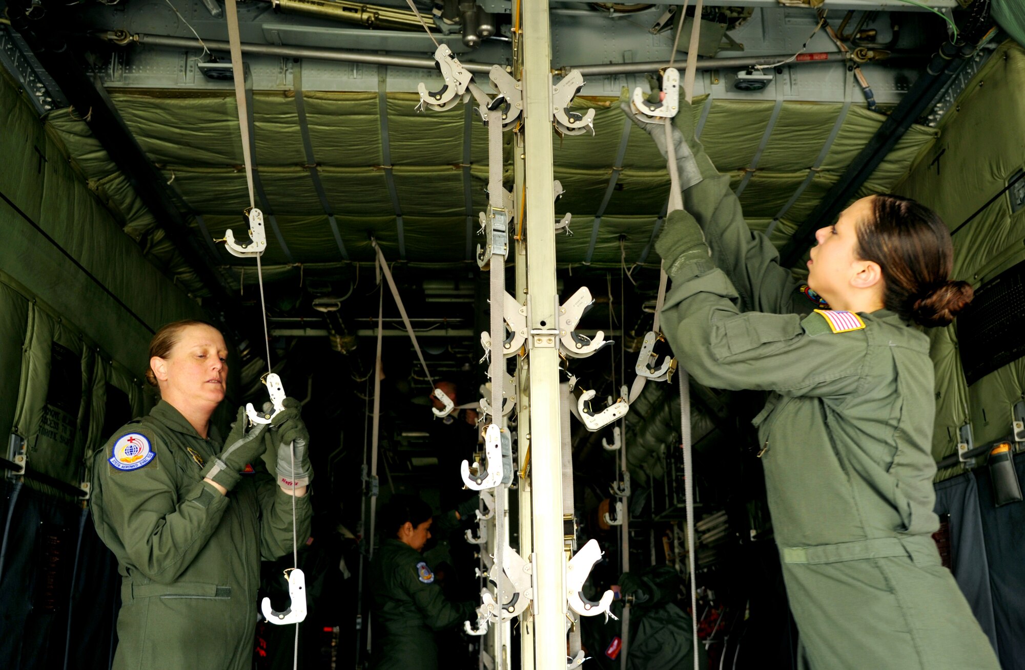 (Left to Right) Capt. Elizabeth Norris, 375th Aeromedical Evacuation Squadron flight nurse and Airman 1st Class Jocelyn Shirley, 187th AES technician configure a C-130 prior to transferring simulated patients during a national disaster exercise, Ultimate Caduceus 2014, at Cheyenne Air National Guard Base, Wyo., March 30, 2014. During Ultimate Caduceus, part of the Federal Emergency Management Agency's  National Capstone Exercise, AE members provided medical support, processed and transferred patients. The aeromedical teams were comprised of more than 18 AE crew members from Pope Army Airfield, N.C., Scott AFB, Il., and Cheyenne ANG base, Wyo. (U.S. Air Force photo/ Staff Sgt. Stephenie Wade)