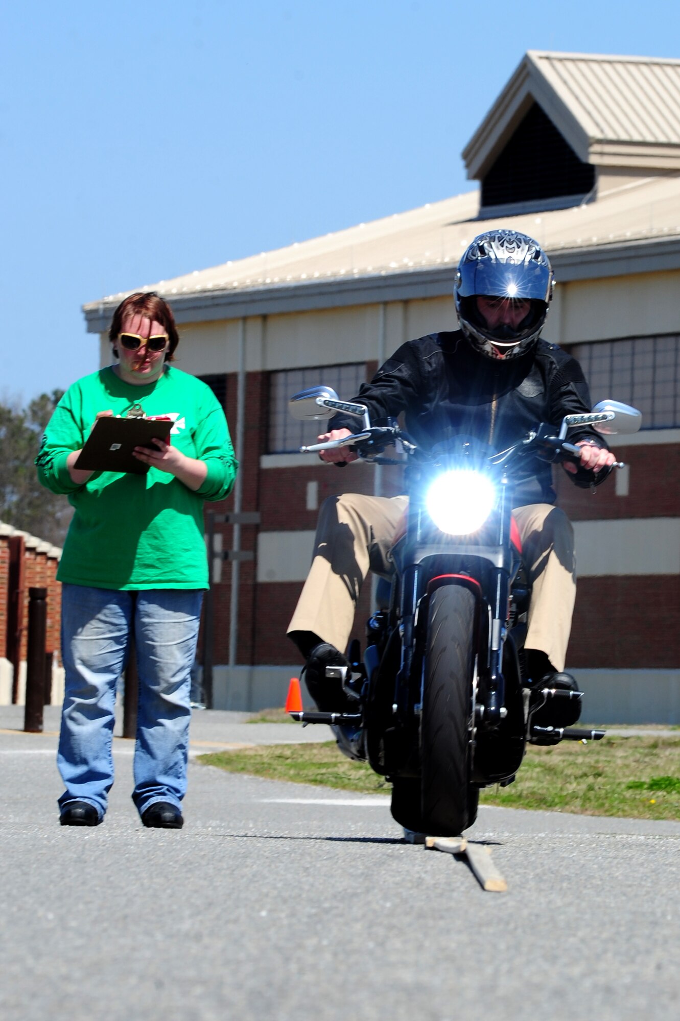 Christina Wiktor, a Green Knights Military Motorcycle Club member, records scores as Jason, 497th Operations Support Squadron analyst, participates in the plank ride event during the 497th Intelligence, Surveillance and Reconnaissance Group’s third annual Motorcycle Safety Day at Langley Air Force Base, Va., April 2, 2014. The plank ride required riders to exhibit proper bike control techniques. (U.S. Air Force photo by Airman 1st Class Areca T. Wilson/Released) (The last name of the subject is withheld for securiy purposes)