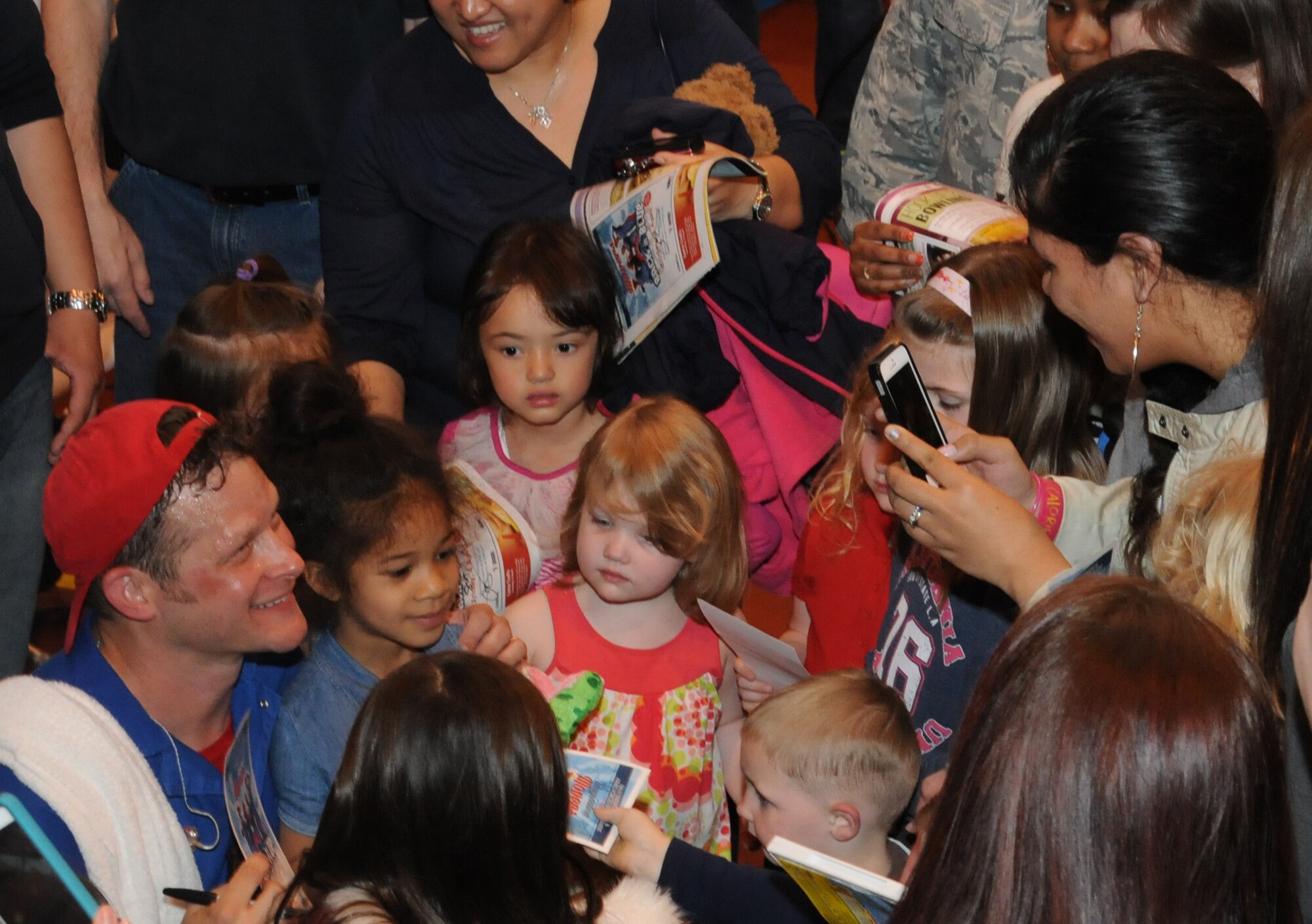 Dave Poche poses for a photograph while signing autographs April 4, 2014, following his performance with the Imagination Movers at RAF Mildenhall, England. The Imagination Movers have sold more than 250,000 CDs and DVDs and are broadcast around the world. (U.S. Air Force photo by Tech. Sgt. Neal X. Joiner/Released)