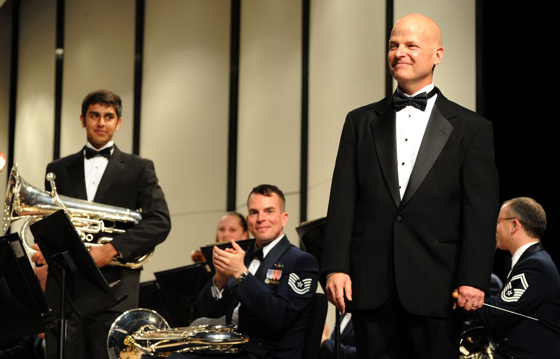 Charles Staley, Neuqua Valley High School director of bands, receives applause after conducting a performance by the U.S. Air Force Band along with students from Neuqua, Waubonsie and Metea Valley High Schools during the 2014 Spring Tour show at Neuqua Valley High School in Naperville, Ill., April 5, 2014.  Tech. Sgt. Joseph M. Bello (center) euphoniumist with the Concert Band and the ensemble Ceremonial Brass, studied under Staley as a middle school student in Naperville.  (U.S. Air Force photo/Master Sgt. Tammie Moore)