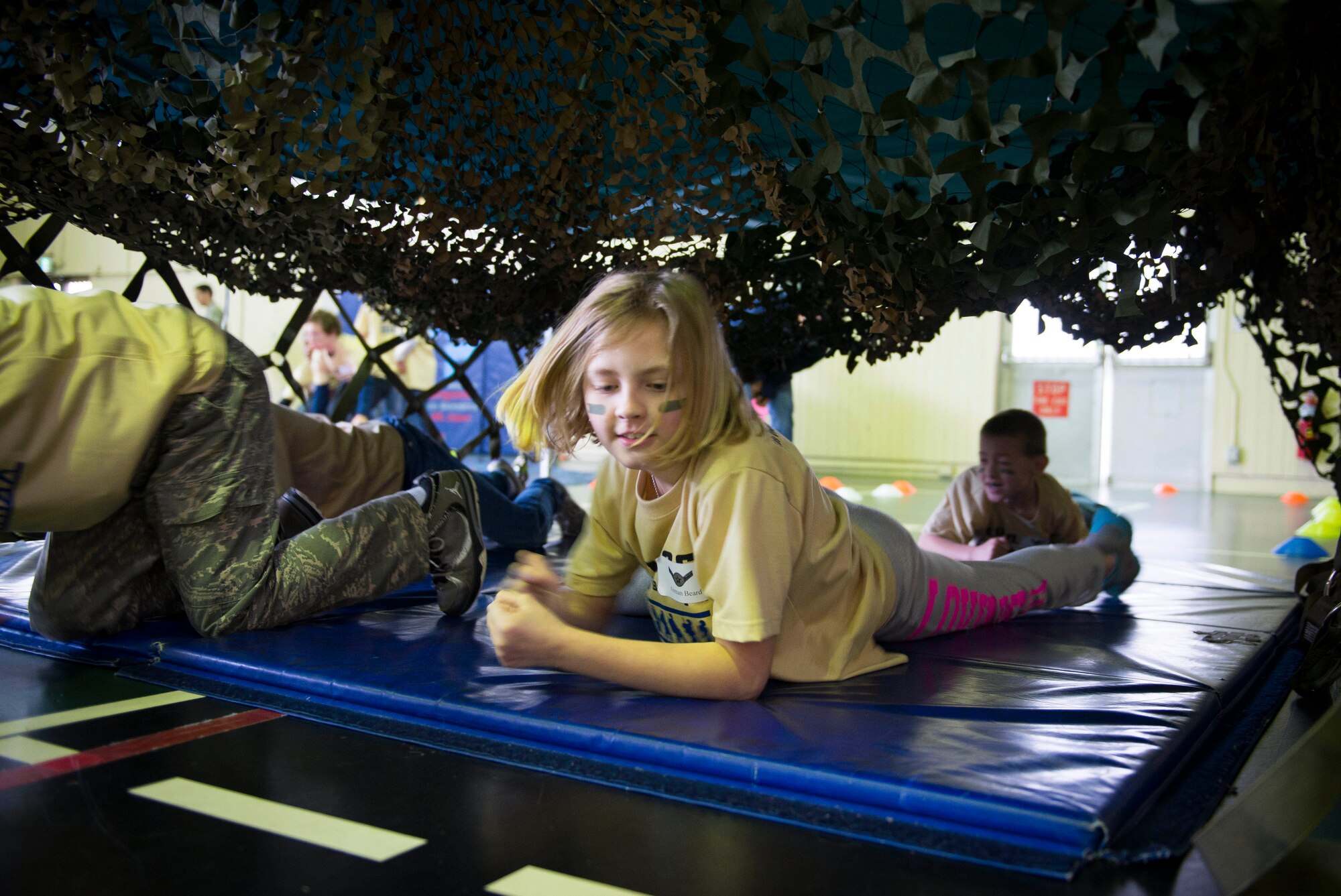 Children participate in an obstacle course during the Kids Understanding Deployment Operations Support program April 4, 2014 at Yokota Air Base, Japan. During KUDOS, children were able to participate in many events including weapons and supply demonstrations and combat face painting. (U.S. Air Force photo by Staff Sgt. Chad C. Strohmeyer/Released)