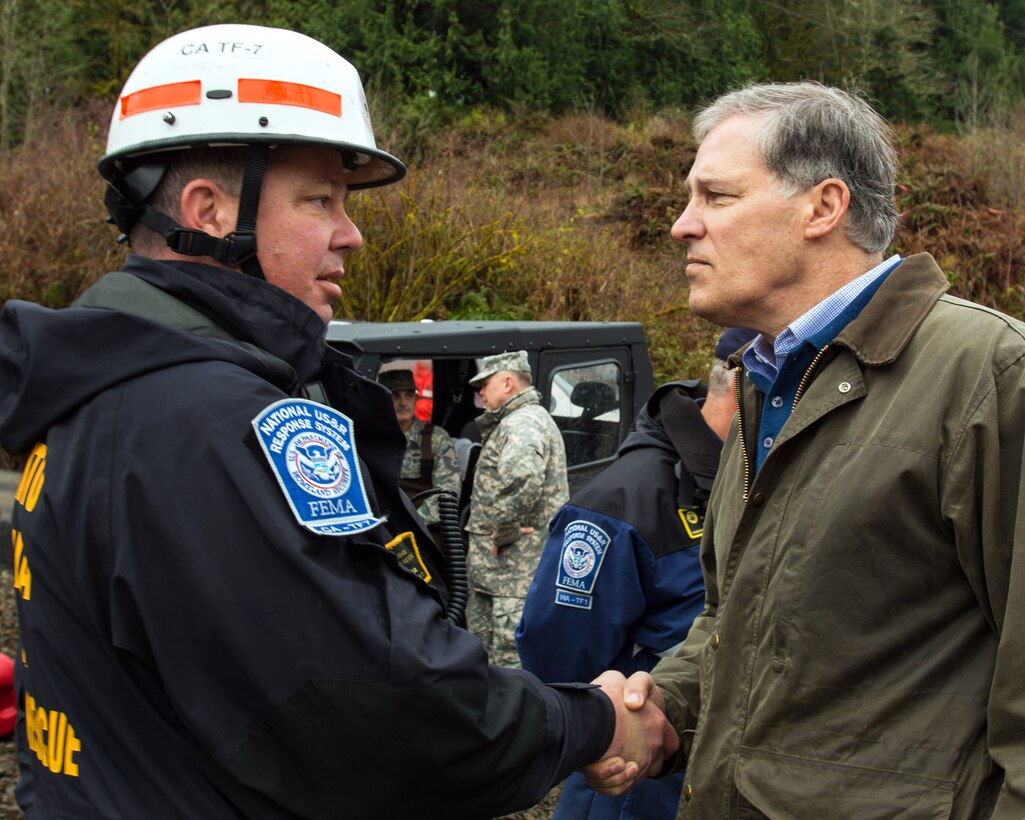 Washington State Gov. Jay Inslee, right, thanks Chris Costanagna for his support in assisting with search operations in Oso, Wash., April 6, 2014, following a deadly mudslide. Costanagna came from Sacramento, Calif., to help.