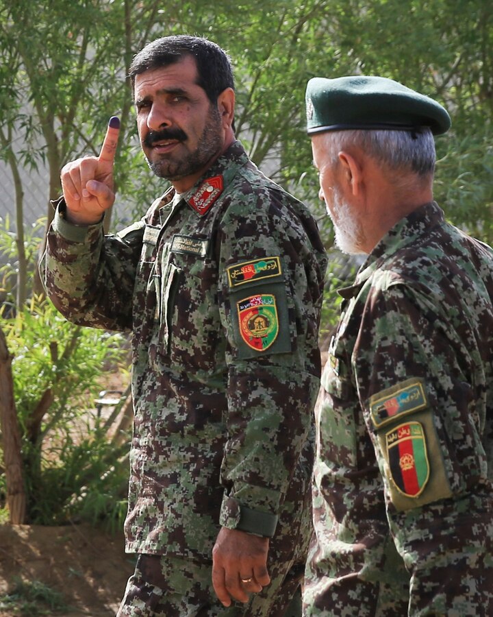Afghan National Army (ANA) Maj. Gen. Sayed Malook, commander of Afghanistan's 215th Corps, shows a purple fingertip as he walks back to the Operational Coordination Center- Regional (OCC-R) aboard Camp Shorabak, Helmand province, Afghanistan, April 5, 2014. A purple fingertip shows that an Afghan citizen voted the 1393 (2014) Afghan presidential elections. 
(Official U.S. Marine Corps photo by Lance Cpl. Darien J. Bjorndal, Marine Expeditionary Brigade Afghanistan/ Not Released)