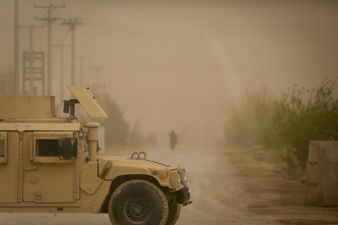 A Afghan Natioanl Army (ANA) soldier assigned to Afghanistan's 215th Corps, walks down a street while an ANA Humvee, guards the Operational Coordination Center- Regional (OCC-R) during the Afghan presidential elections, in the midst of a sandstorm, aboard Camp Shorabak, Helmand province, Afghanistan, April 5, 2014. The 1393 (2014) presidential elections is the first year Afghan National Security Forces (ANSF) have taken the lead for such an event.
(Official U.S. Marine Corps photo by Lance Cpl. Darien J. Bjorndal, Marine Expeditionary Brigade Afghanistan/ Not Released)