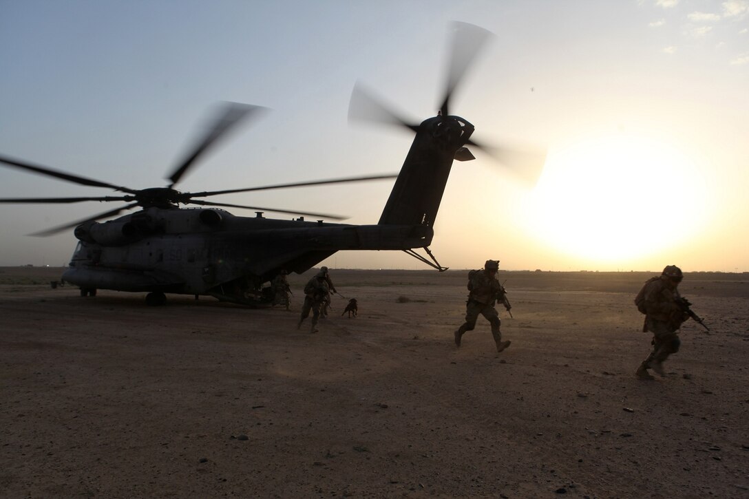 Marines with the Georgian Liaison Team and Georgian soldiers from the 31st Georgian Light Infantry Battalion quickly exit a CH-53E Super Stallion as they are inserted into a training area in Helmand province, Afghanistan, April 2, 2014. The Super Stallions inserted the Georgian soldiers and Marines of the GLT at the training site as the sun sat just above the horizon, leaving behind a swirling cloud of dirt and rocks as they took off. For the platoon of Georgian soldiers, this was their first time conducting a training mission with a helicopter. (USMC Photo By: Sgt. Frances Johnson/Released)