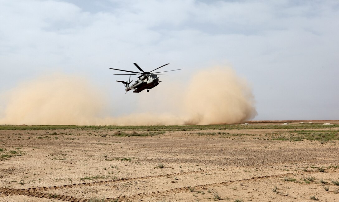 A CH-53E Super Stallion with Marine Heavy Helicopter Squadron 466 prepares for landing to pick up Marines of the Georgian Liaison Team and a platoon from the 31st Georgian Light Infantry Battalion from a training exercise in Helmand province, Afghanistan, April 2, 2014. The Super Stallions inserted the Georgian soldiers and Marines of the GLT at the training site as the sun sat just above the horizon, leaving behind a swirling cloud of dirt and rocks as they took off. For the platoon of Georgian soldiers, this was their first time conducting a training mission with a helicopter. (USMC Photo By: Sgt. Frances Johnson/Released)
