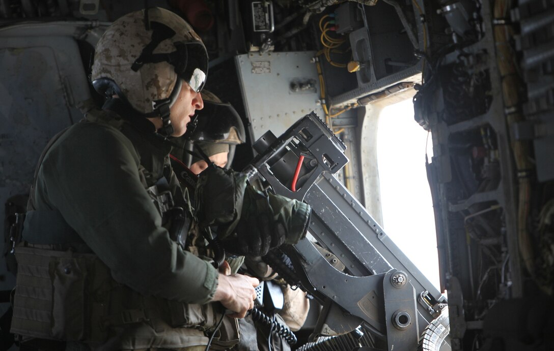 First Lt. John Moore, intelligence officer and aerial observer with Heavy Helicopter Squadron 466 prepares to take photos for an aerial reconnaissance mission over Helmand province, Afghanistan, April 2, 2014. The Super Stallions conducted an aerial reconnaissance mission in support of ground troops by flying over areas of interest and bringing back requested information. (USMC Photo By: Sgt. Frances Johnson/Released)