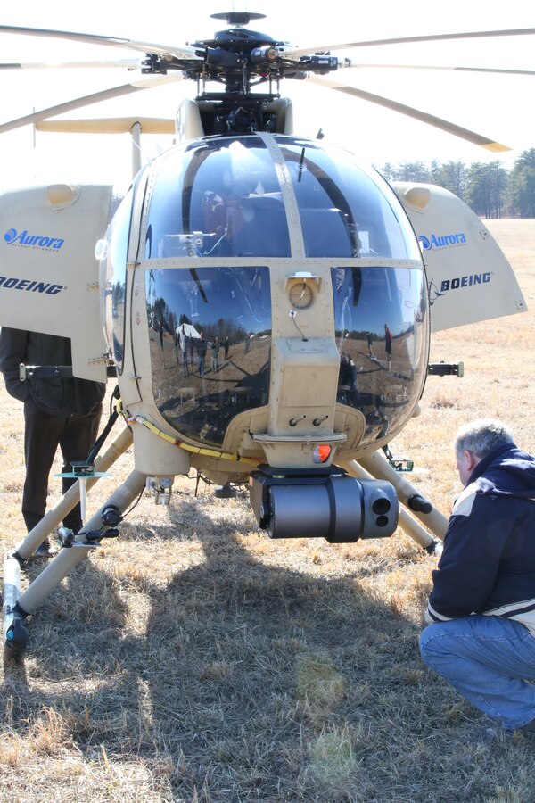 An attendee examines the Autonomous Aerial Cargo/Utility System (AACUS) prototype during a demonstration at Marine Corps Base Quantico on Feb. 27, 2014. AACUS is a series of sensors and aircraft software that enables a Marine or other operator to arrange for a landing by an unmanned or manned rotary-wing aircraft to an unprepared landing site. 