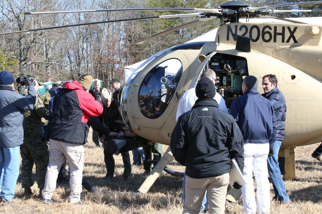 Participants examine an Autonomous Aerial Cargo/Utility System prototype during a demonstration on Marine Corps Base Quantico on Feb. 27, 2014.  AACUS is a series of sensors and aircraft software that enables a Marine or other operator to arrange for a landing by an unmanned or manned rotary-wing aircraft to an unprepared landing site.