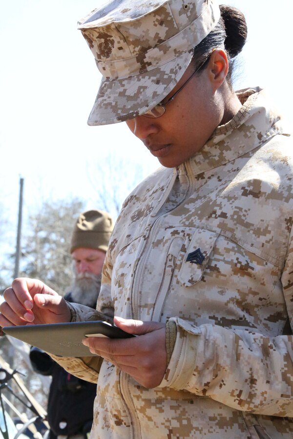 Sgt. Jessica Wright, a field wireman currently serving as an augment to Security Battalion, MCB Quantico, lands a helicopter using a tablet during an Autonomous Aerial Cargo/Utility System (AACUS) prototype demonstration at Marine Corps Base Quantico on March 20, 2014. AACUS is a five-year, $98 million dollar effort spearheaded by the Office of Naval Research.