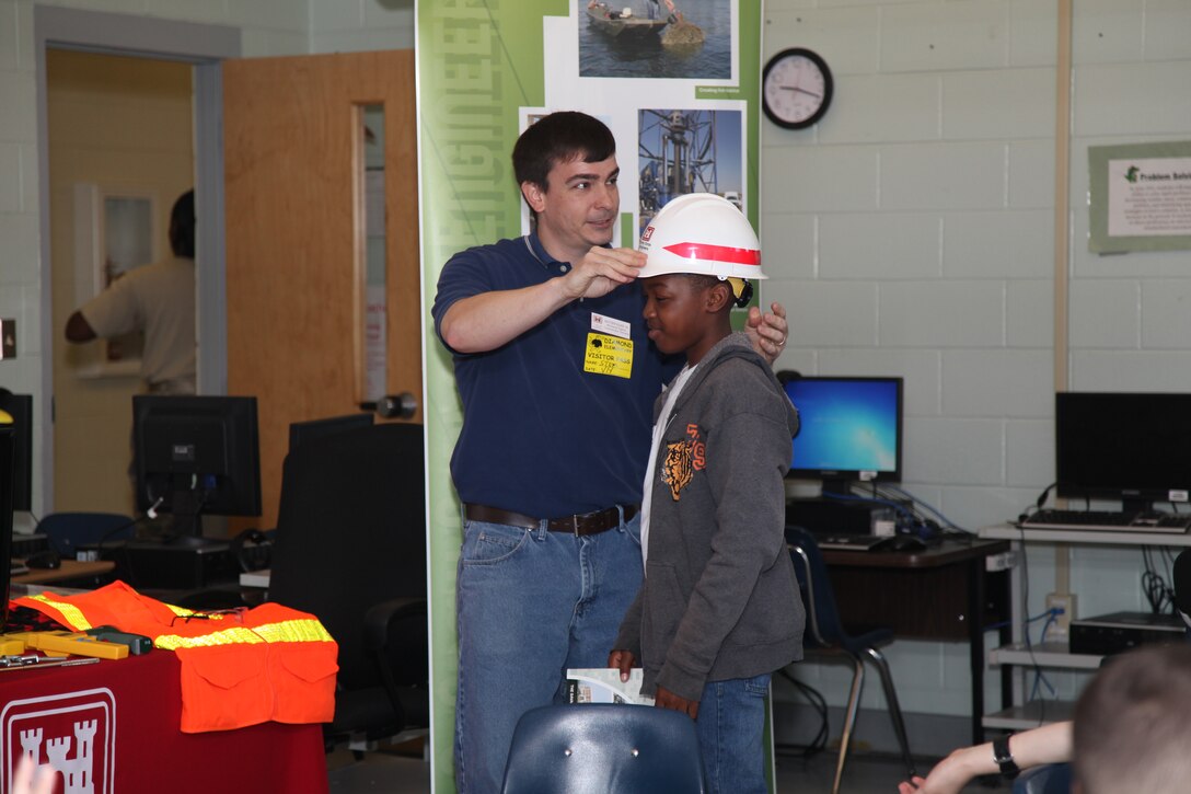 FORT STEWART, Ga. – Matt Kilmer, a mechanical engineer with the U.S. Army Corps of Engineers Savannah District, Fort Stewart Resident Office, demonstrates the importance of safety on a job site during a school-wide "STEMposium" at Diamond Elementary School, April 4, 2014. The event focused on getting children interested in Science, Technology, Engineering and Math (STEM) career fields.