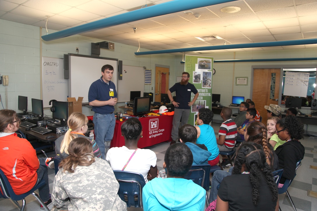 FORT STEWART, Ga. – Mechanical Engineer Matt Kilmer (left) and Civil Engineer Craig Walters with the U.S. Army Corps of Engineers Savannah District, Fort Stewart Resident Office, talk to students at Diamond Elementary School about engineering careers with the Corps during a school-wide "STEMposium" April 4, 2014. The event focused on getting children interested in Science, Technology, Engineering and Math (STEM) career fields. 