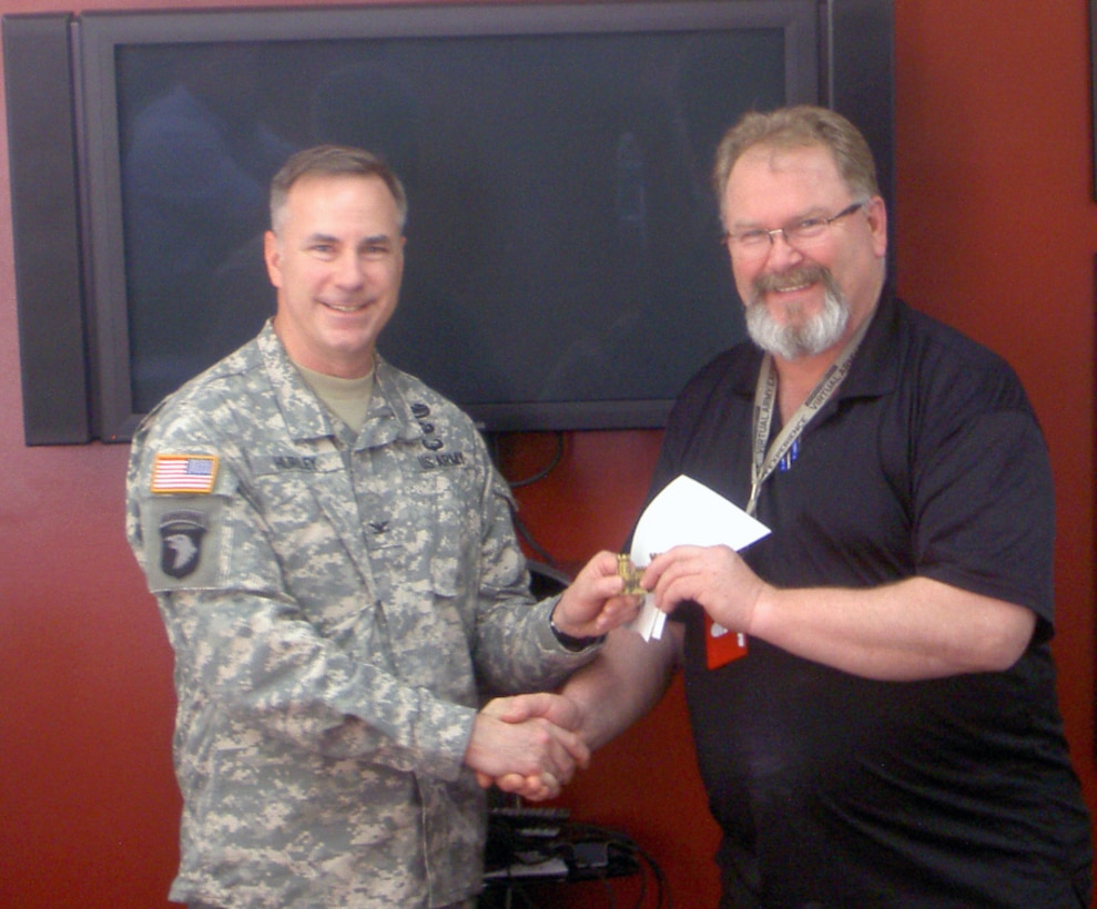 Iwakuni Resident Office Construction Inspector David Daggett receives a USACE Chief's Coin from JED Commander John Hurley on March 27. Daggett was recognized for his efforts in leading the Science, Technology, Engineering and Mathematics (STEM) program with schools and grade 9 through 12 students in the MCAS Iwakuni area.   
