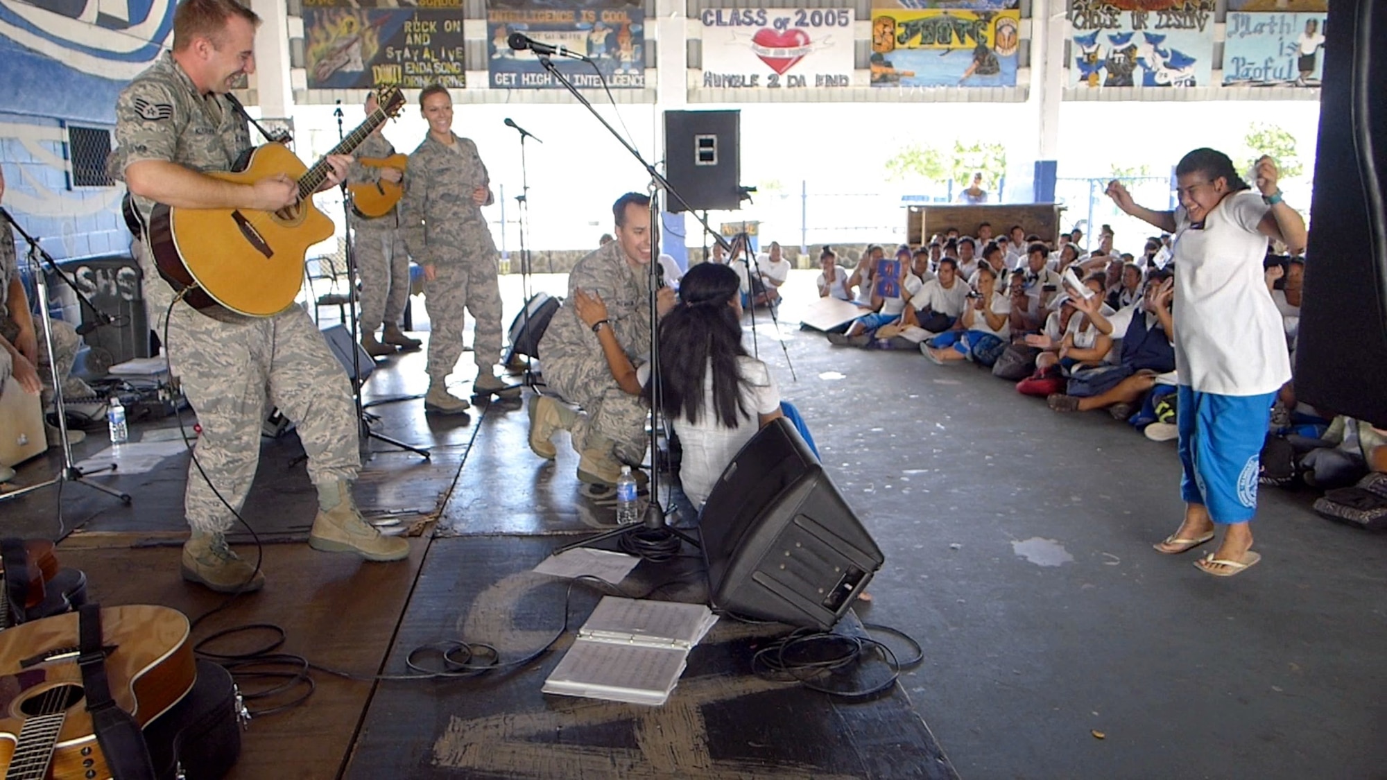 UTULEI BEACH, American Samoa-- SrA Devin Rivas Martin serenades one of the students from Samoana High School in front of a very excited audience member on March 26, 2014. (US Air Force Photo/Michael Smith/ Released)